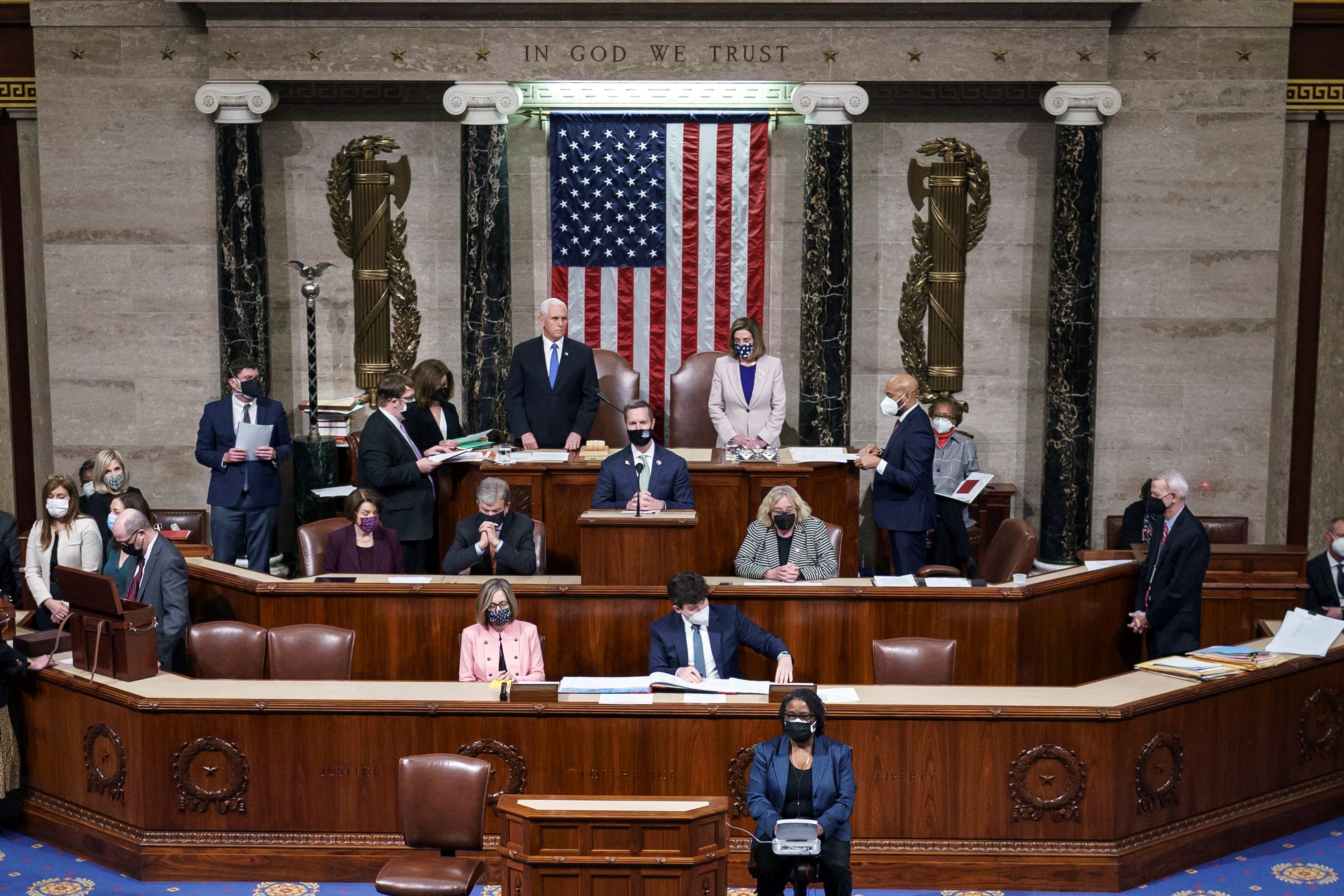 Le vice-président américain Mike Pence et la présidente de la Chambre des représentants Nancy Pelosi se lèvent après avoir lu la certification finale des votes du collège électoral au Capitole, le 7 janvier 2021 (AFP)