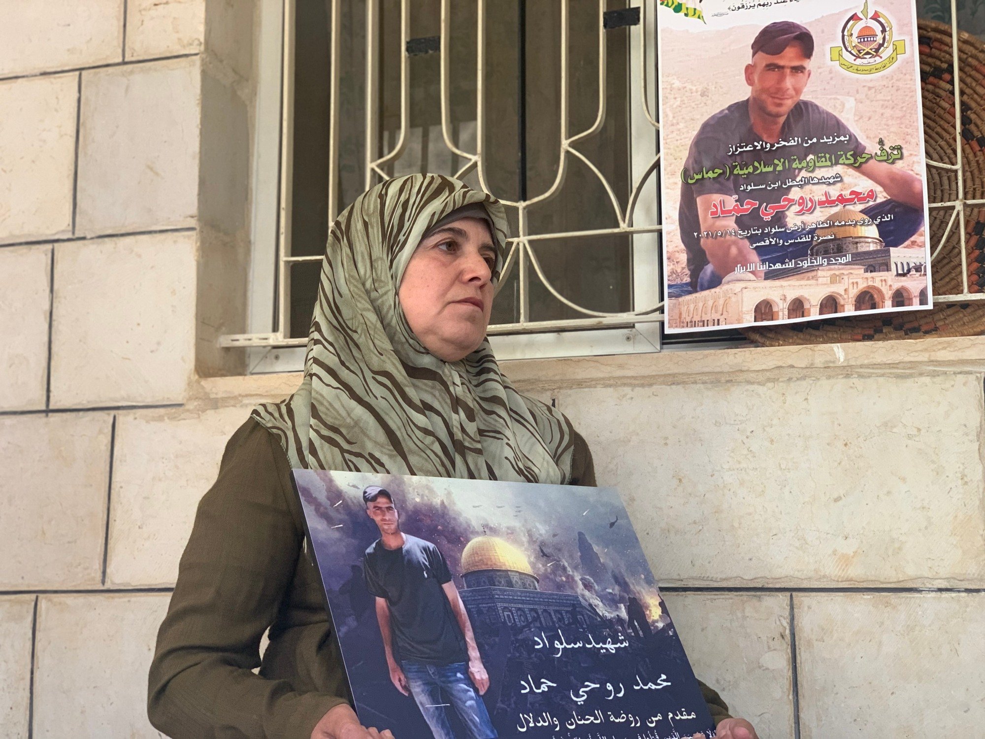 Fatima Hammad tient un portrait de son fils dans la ville occupée de Silwad en Cisjordanie occupée (MEE/Shatha Hammad)