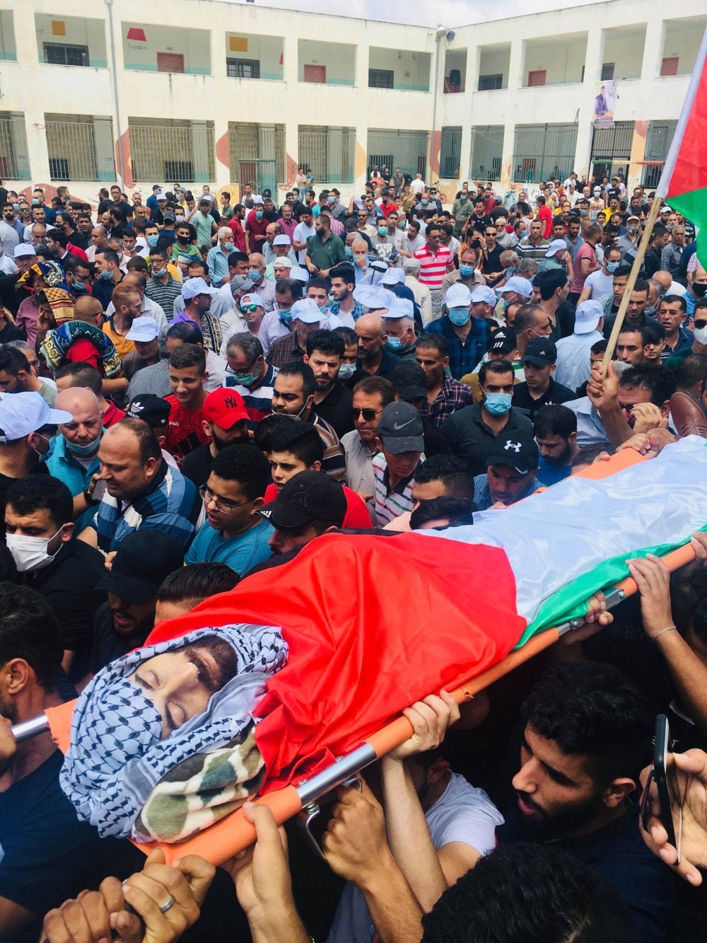 Mourners carry Ibrahim Abu Yaaqoub's body during his funeral in the Palestinian village of Kifl Haris on 10 July 2020 (MEE/Akram al-Waara)