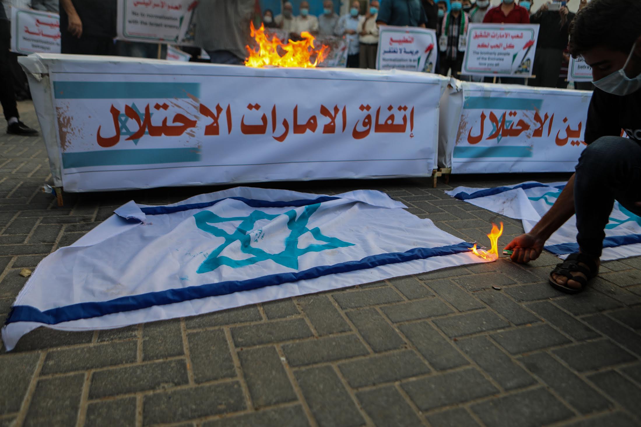 Banners labeled "Emirates' deal with the occupation" and "Bahrain's deal with the occupation" were set on fire during a Gaza protest (MEE/Muhammed Alhajjar)