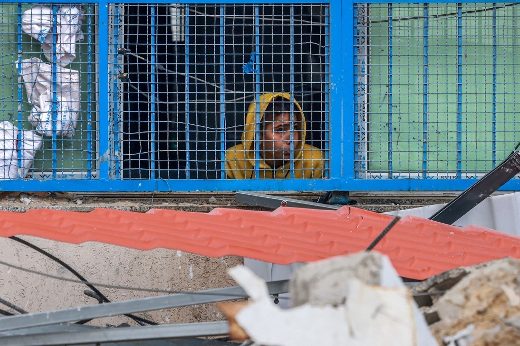 A young Palestinian looks out from a UN school in Rafah sheltering displaced people after an Israeli strike hit a nearby house (Mohammed Abed/AFP)