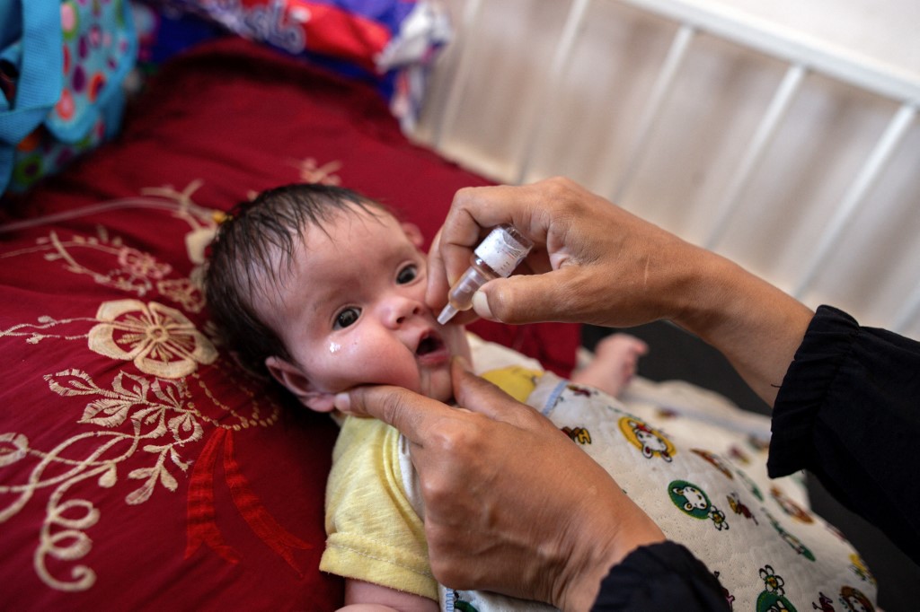 A nurse administers Polio vaccine drops to a young Palestinian patient at the Nasser hospital in Khan Yunis in the southern Gaza Strip on August 31, 2024 (AFP/Jihad Al-Sharafi)