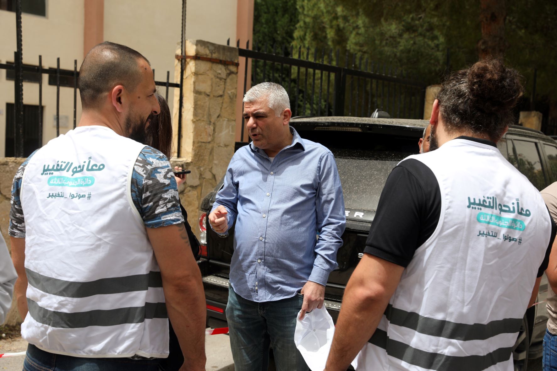 Hassan Bazzi talks to two volunteers with Together Towards Change (MEE/Heba Nasser)