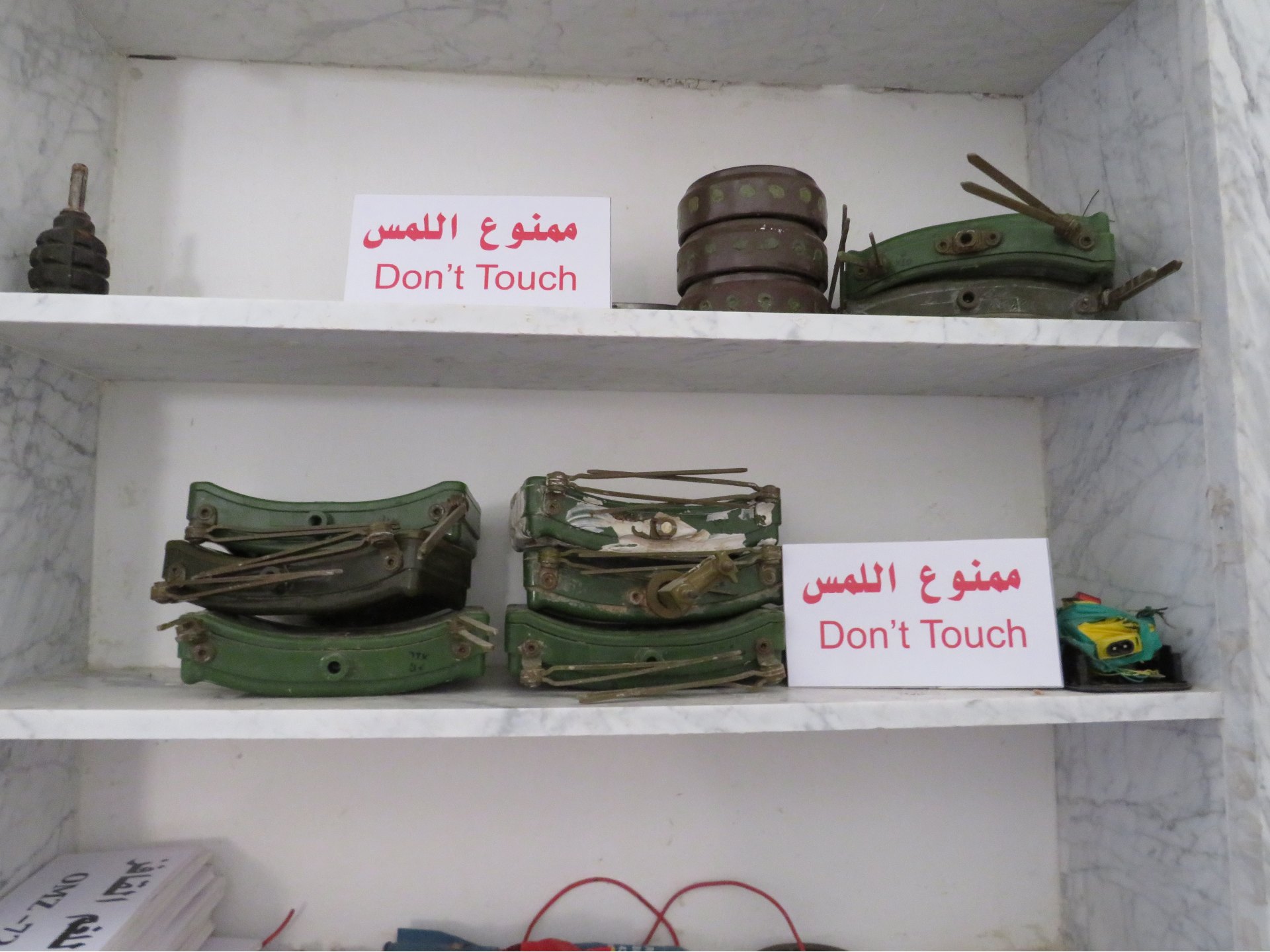 Eight MON-50 mines displayed on a shelf in a Tripoli military base (MEE/Daniel Hilton)