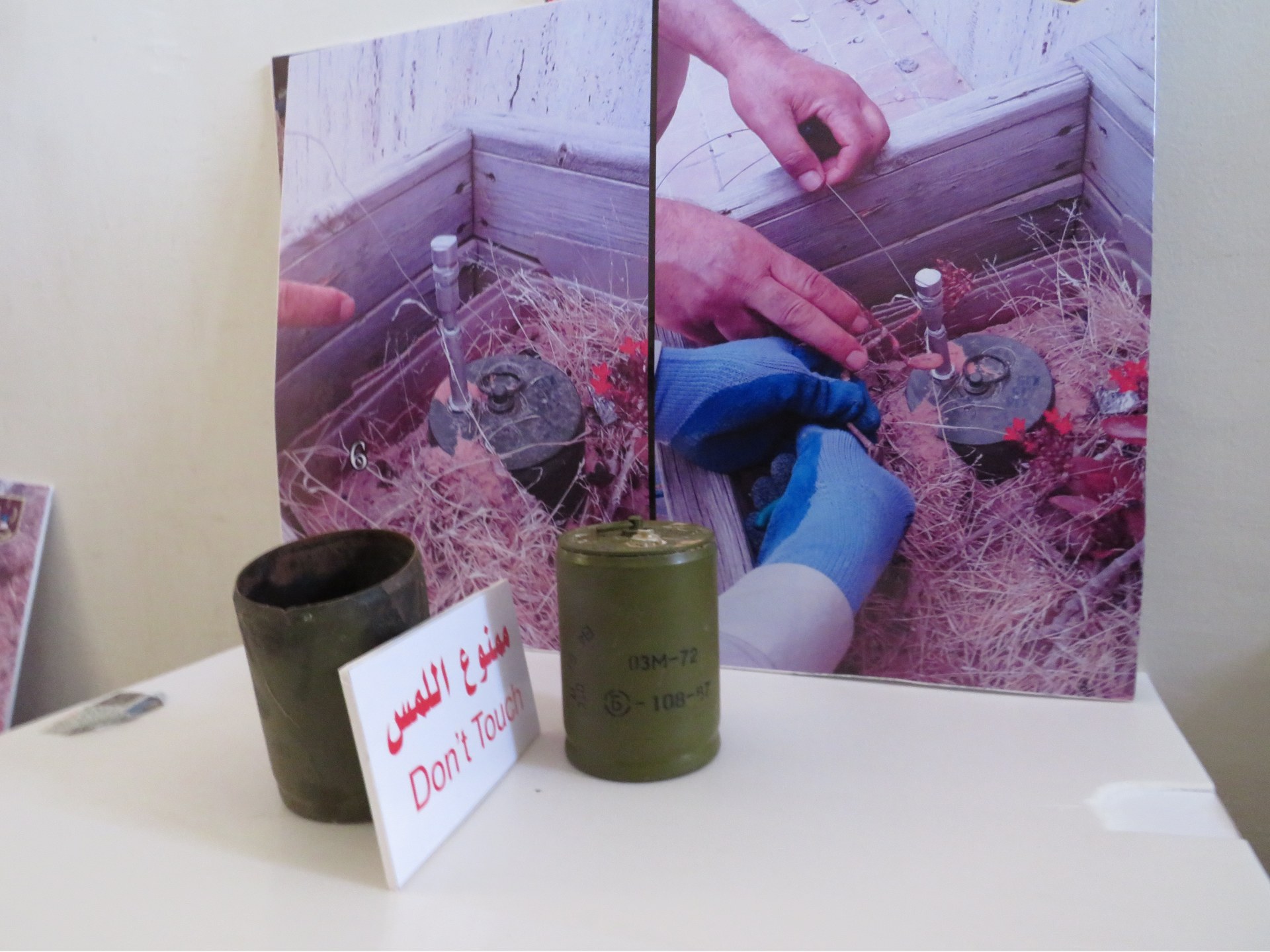 OZM-72 mines in front of photographs of one of their model found in situ in Tripoli (MEE/Daniel Hilton)