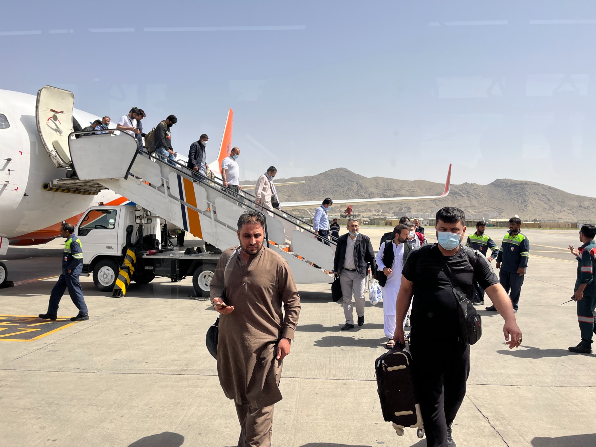 Afghans disembark the plane at Kabul airport (MEE/Ali M Latifi)