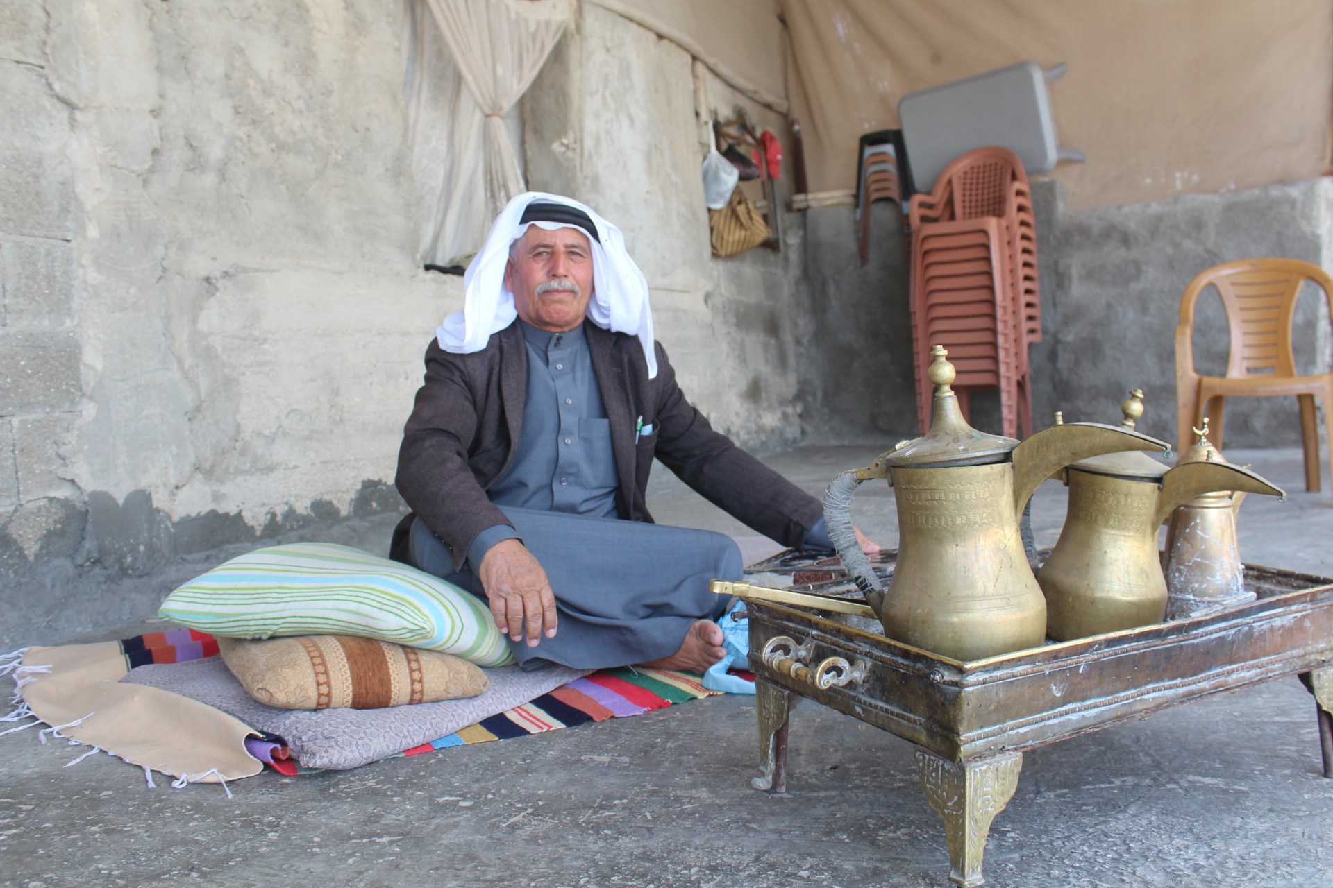 Faqra sits amongst possessions he still has from the home he lost in 1948 (MEE/Shatha Hammad)