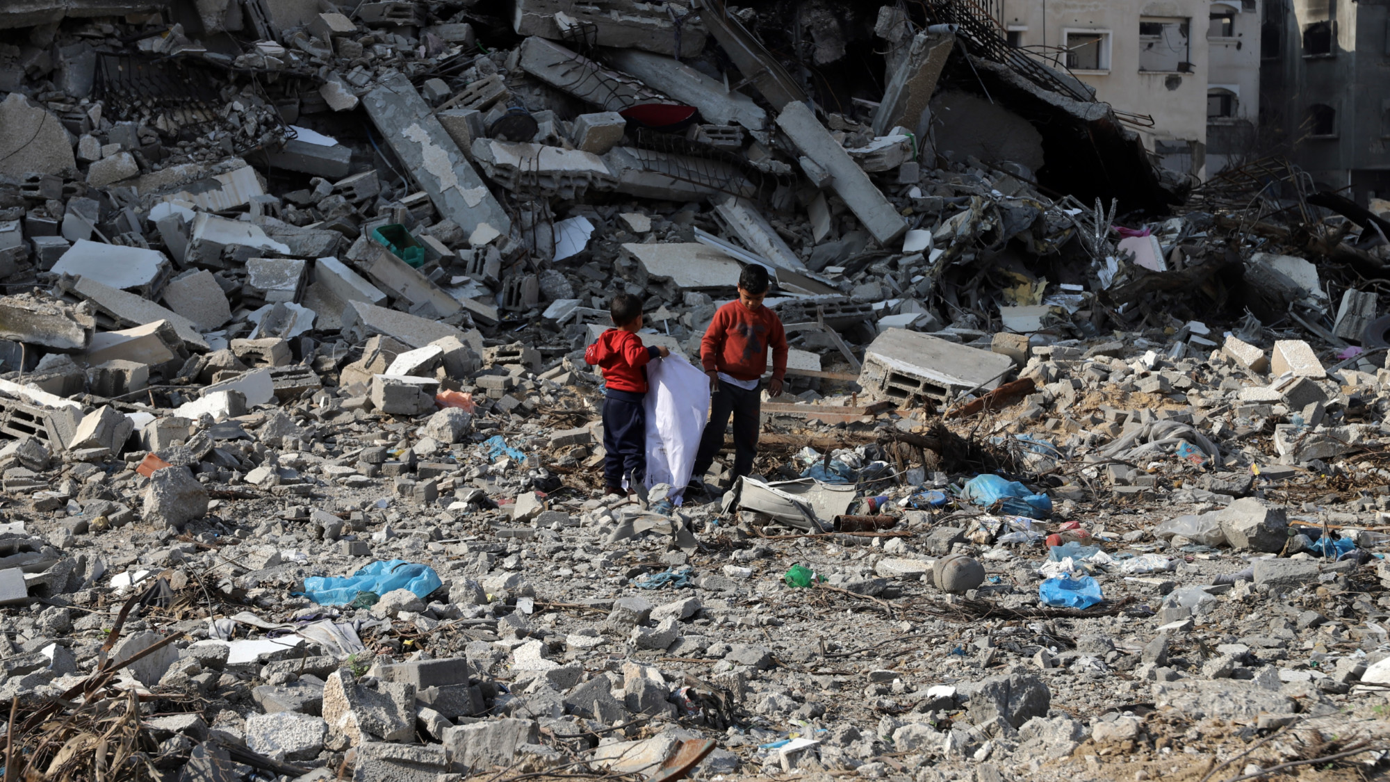 Des enfants fouillent les décombres de leurs maisons détruites à Gaza, le 12 janvier 2023 (MEE/Mohammed al-Hajjar)