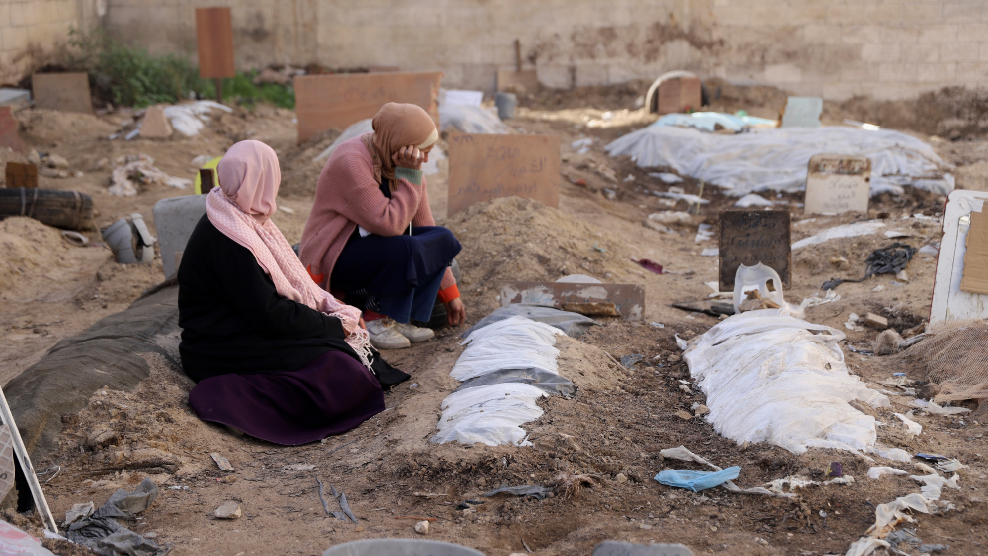Des Palestiniennes pleurent un proche tué lors d’une frappe aérienne israélienne dans un cimetière surpeuplé de Gaza, le 13 janvier 2024 (MEE/Mohammed al-Hajjar)