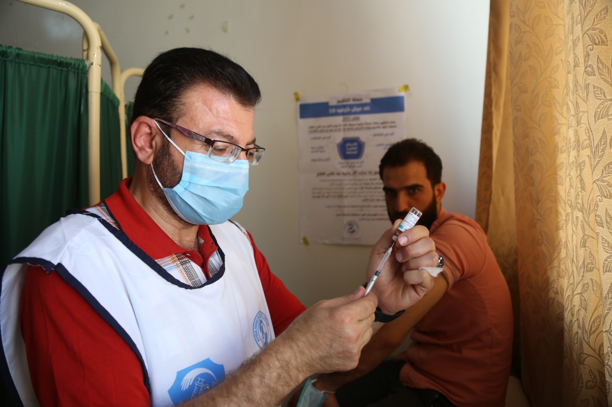 A health care worker administers a vaccine in the Syrian city of Idlib on 26 August (MEE/Ali Haj Suleiman)