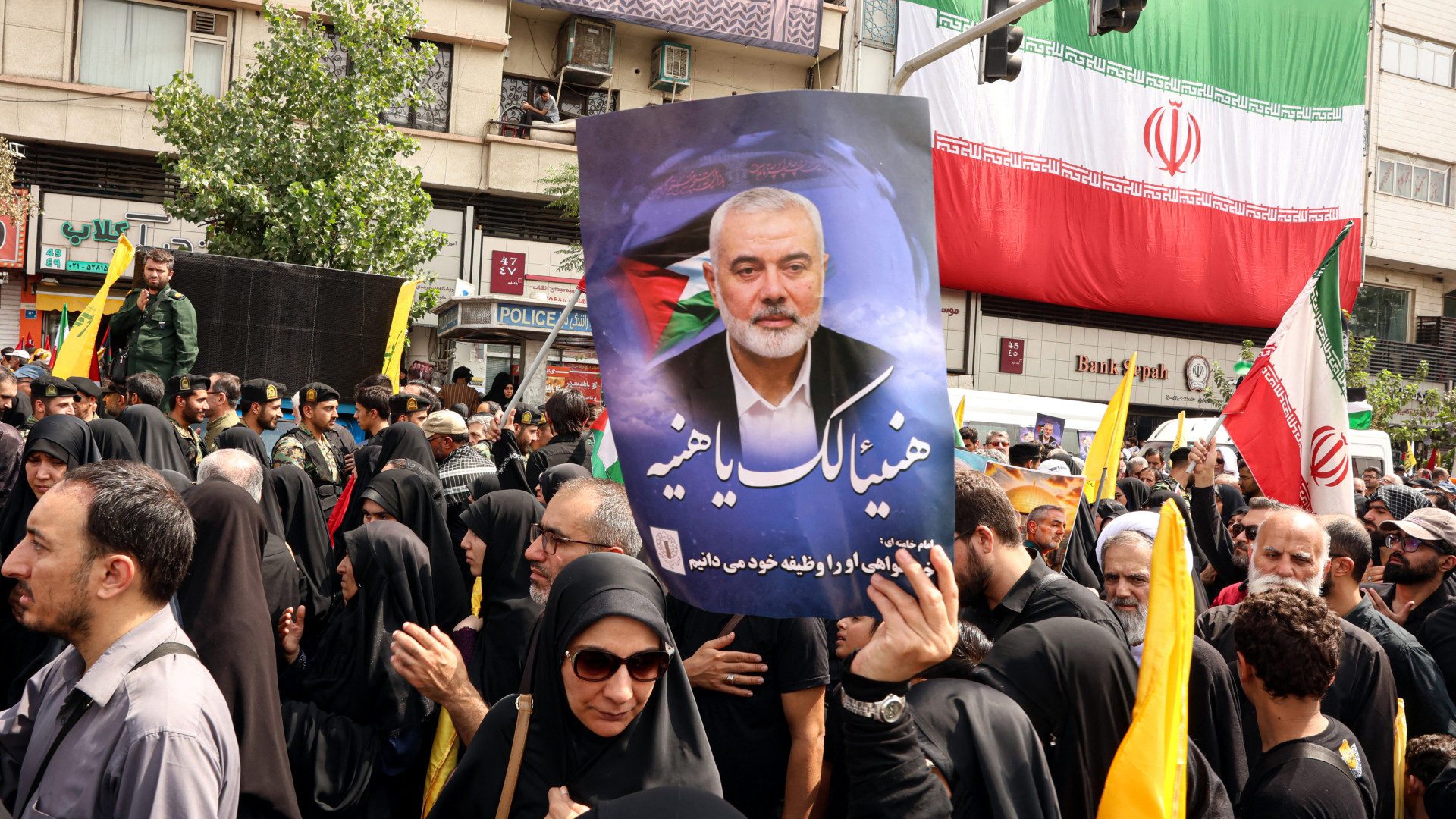 Iranians hold portraits of late Hamas leader Ismail Haniyeh during his funeral procession, in Tehran, on 1 August ahead of his burial in Qatar (AFP)