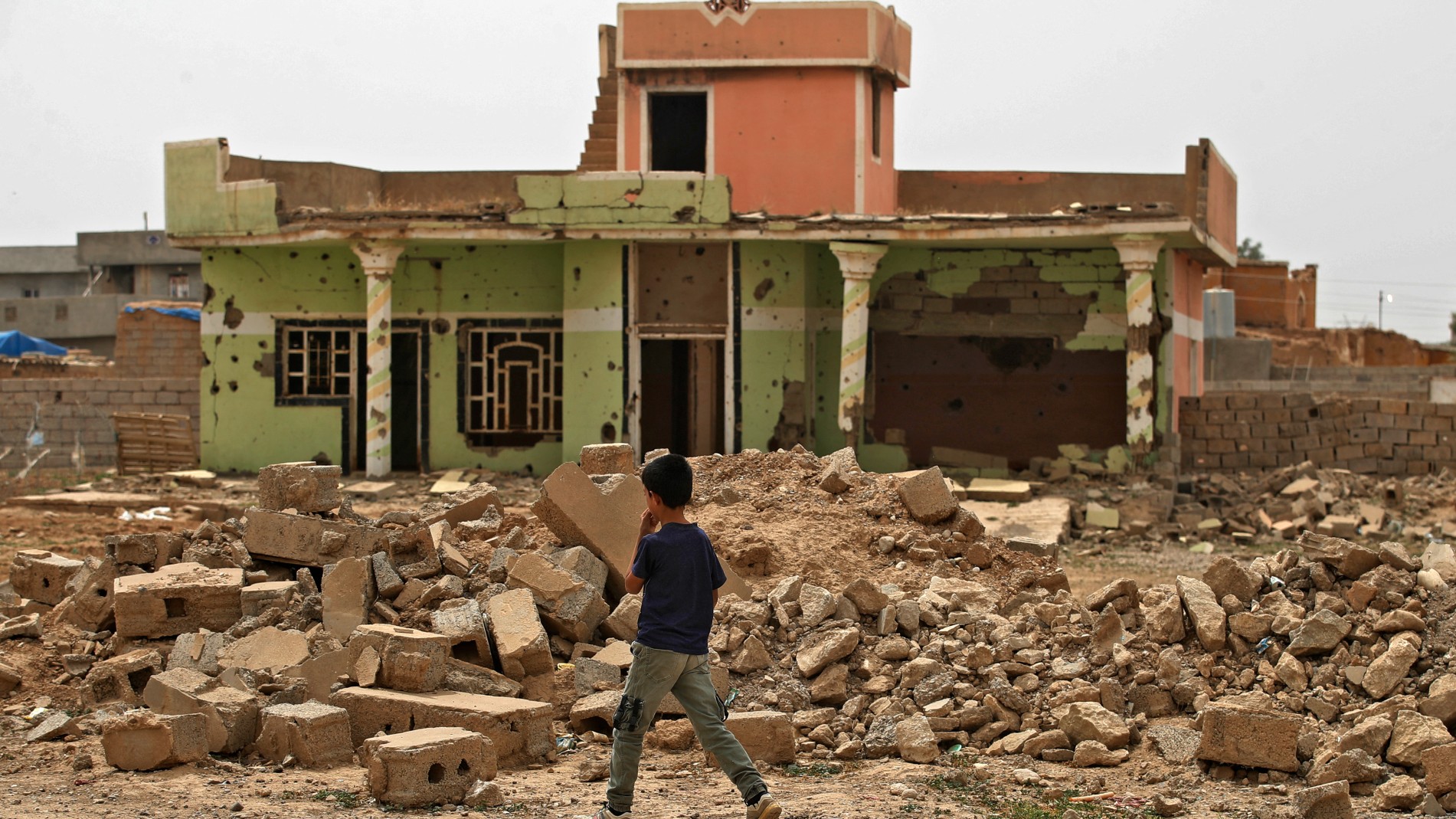 A boy walks past a destroyed house in the war-ravaged village of Habash, some 180 kilometres north of Iraq's capital Baghdad, on 25 April, 2022.