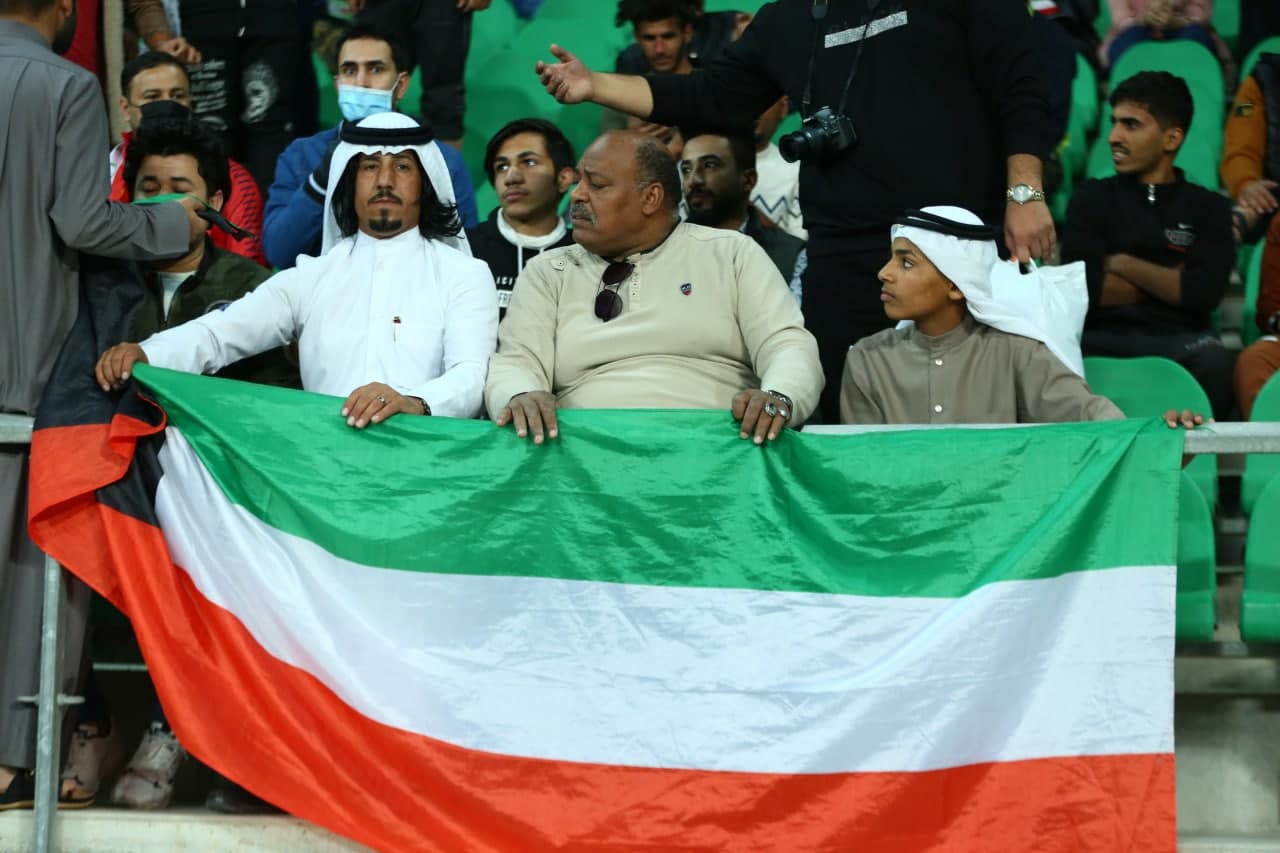 Iraqis carrying the Kuwait flag, expressing a warm welcome to their rivals
