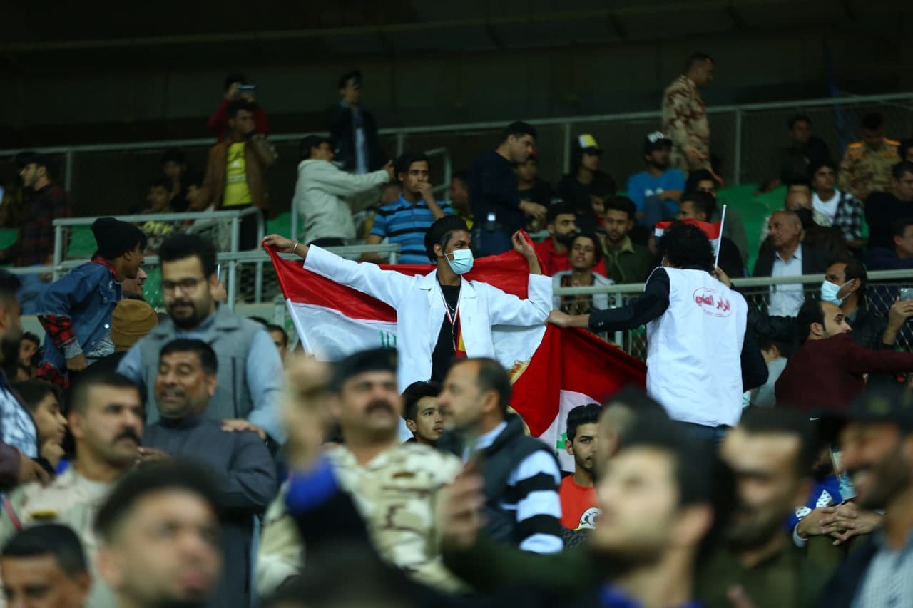 Iraqis who attended the match encourage both football teams inside the Basra International Stadium.