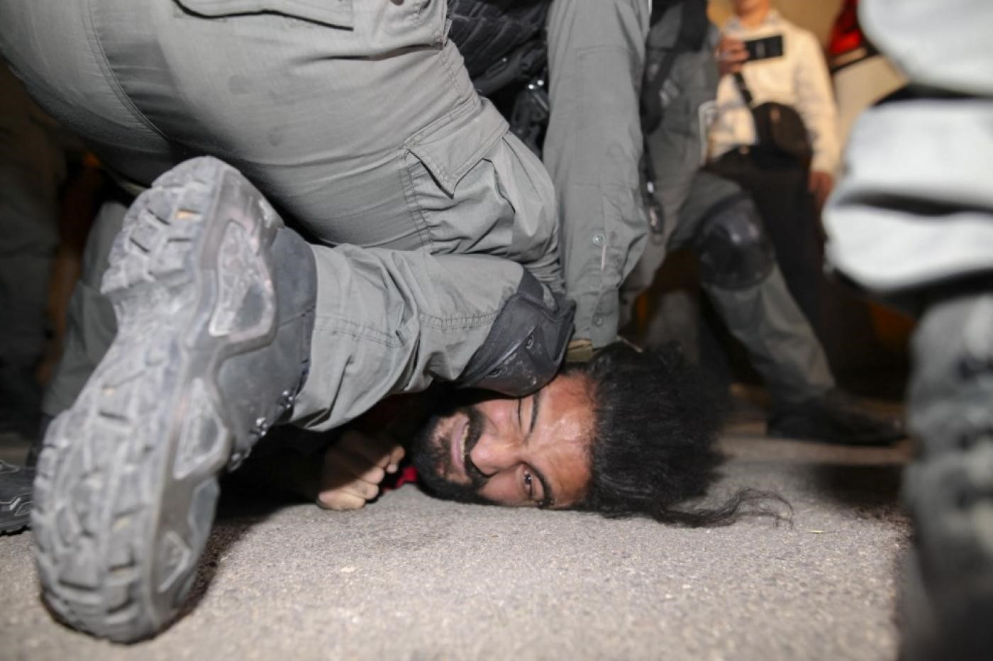 Israeli security forces detain a Palestinian man as families face eviction in Sheikh Jarrah on 4 May 2021 (AFP)