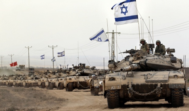 Israeli soldiers on tanks fly their national flag (AFP)