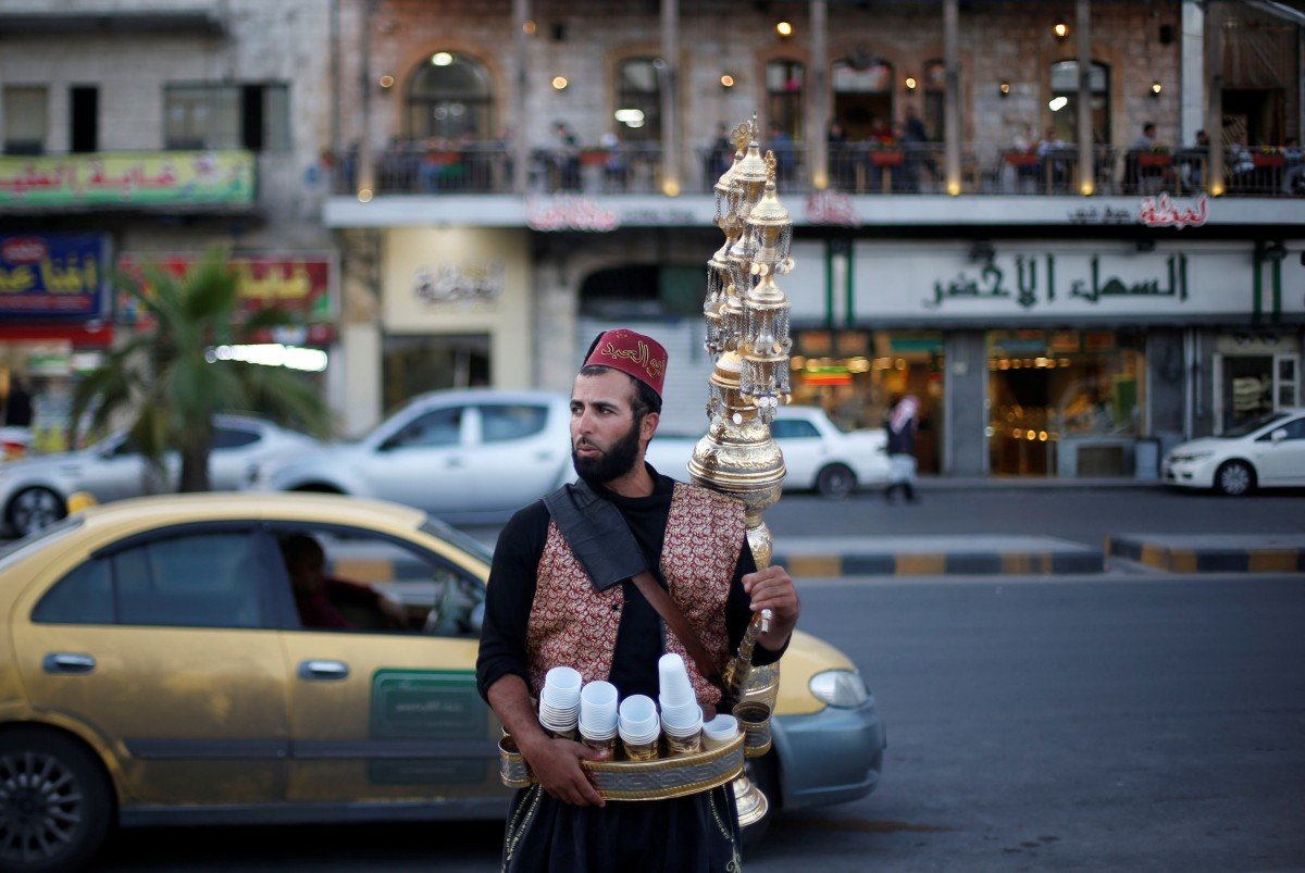 Un vendeur de jus de fruits traditionnel attend les clients dans le quartier de l’amphithéâtre romain dans le centre d’Amman (Reuters)