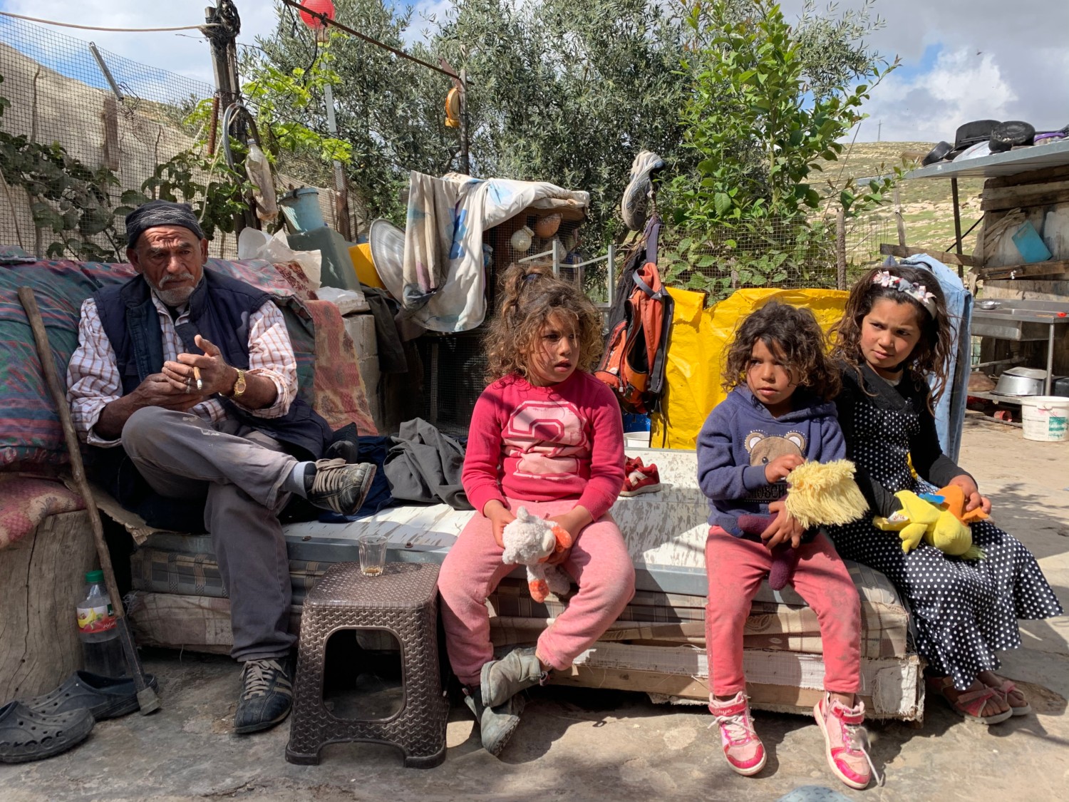 Issa Abu Kabbash with his daughters (from left) Narmin, Eman and Maram outside their home (MEE/Shatha Hammad)