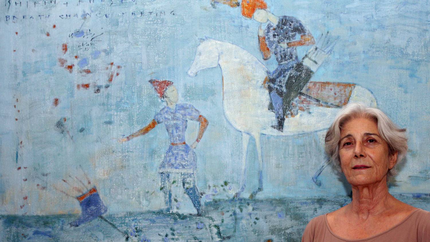 Kuwait has a well-established art scene, here curator Lucia Topalian, director of the Dar al-Funoon art gallery stands beside a painting by Iranian artist Reza Derakshani (Asser Al-Zayyat/AFP)