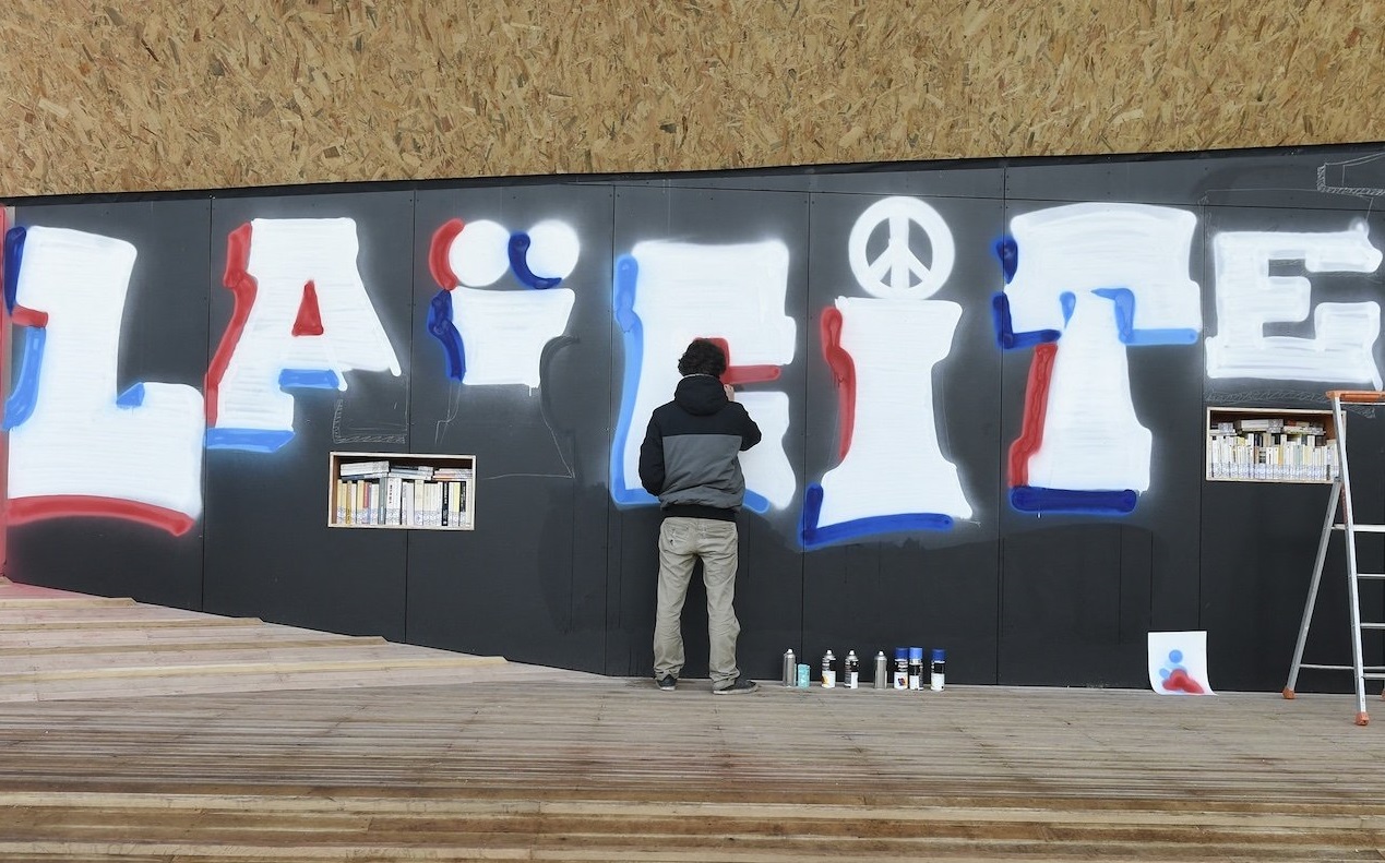 Un artiste écrit « Laïcité » lors de l’inauguration de la « place de la Laïcité » à Paris, le 9 décembre 2015 (AFP)