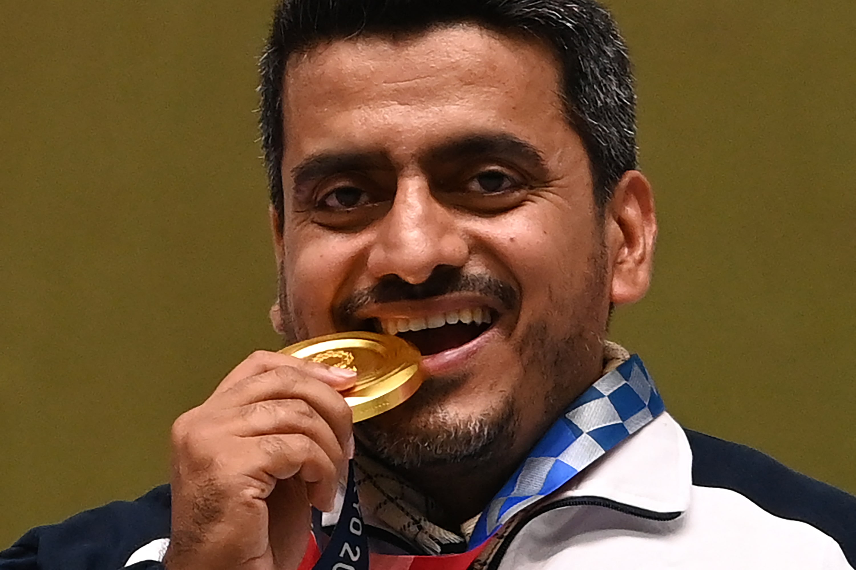 Le médaillé d’or iranien Javad Foroughi célèbre sa victoire en finale du pistolet à air comprimé 10 mètres sur le podium (AFP)