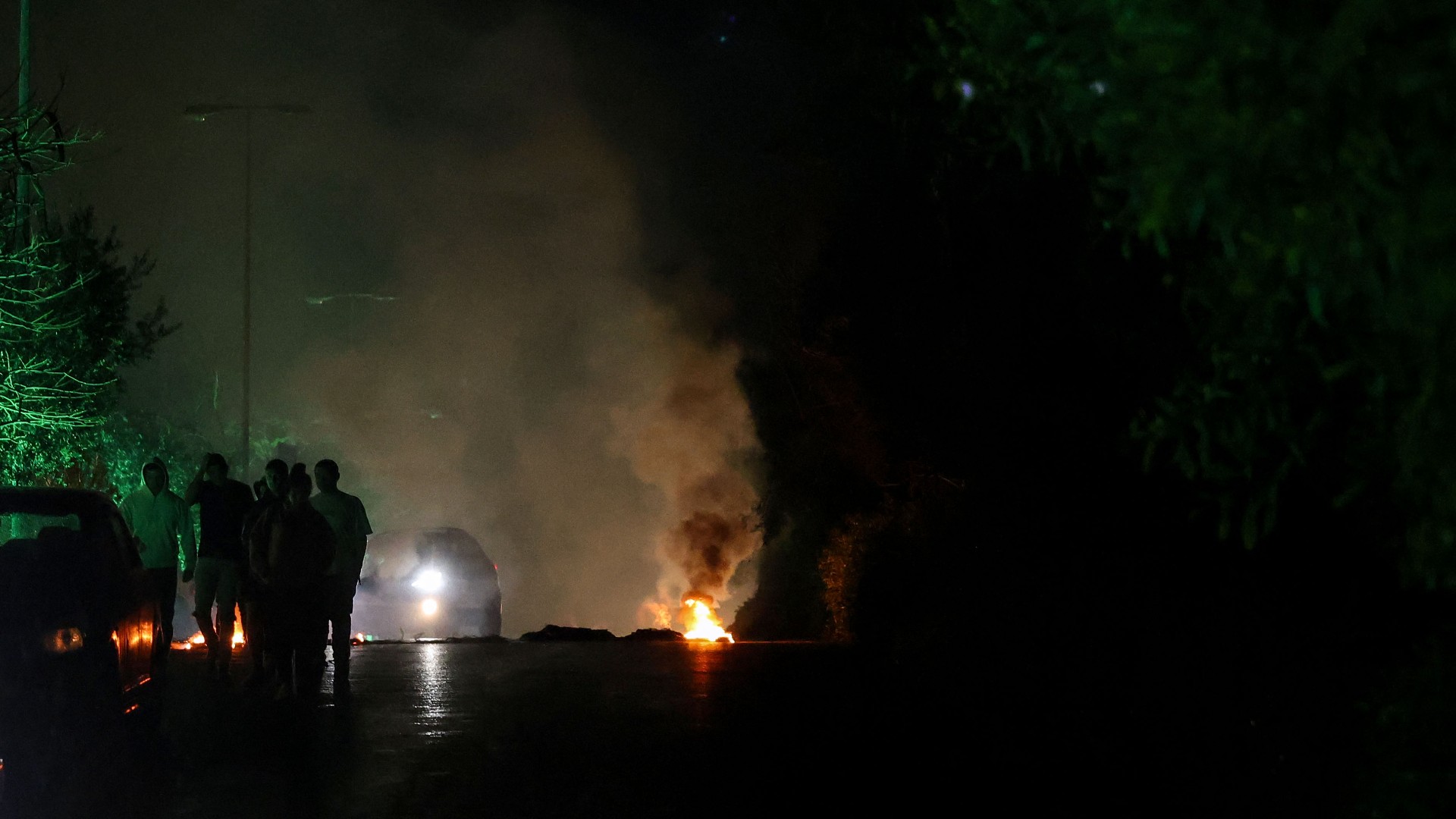 Partisans of the Christian Lebanese Forces burn rubble on the side of a road to protest the killing of Pascal Sleiman in the Jbeil area, on 8 April (AFP/Joseph Eid)