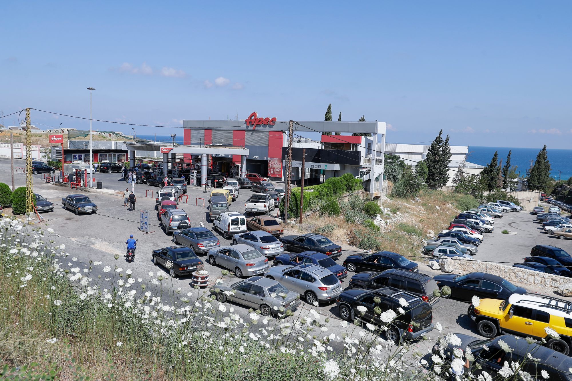 Vehicles queue up at a petrol station in the Balamand area on the coastal highway linking Lebanon's capital to the country's north on 21 June 2021 (AFP)