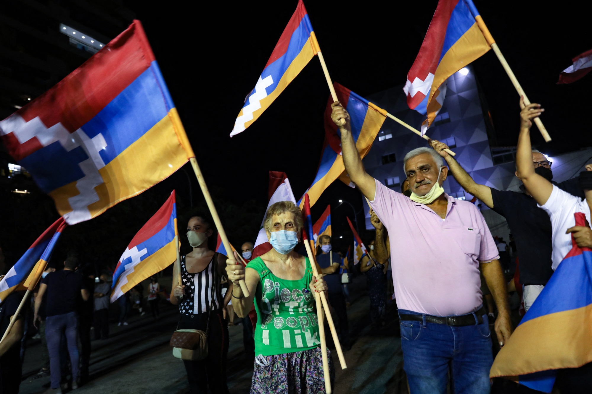 Lebanese of Armenian origin raise Armenian, national and Nagorno-Karabakh flags as they take part in a rally in the Beirut suburb of Burj Hammoud on 9 October 2020 (AFP)