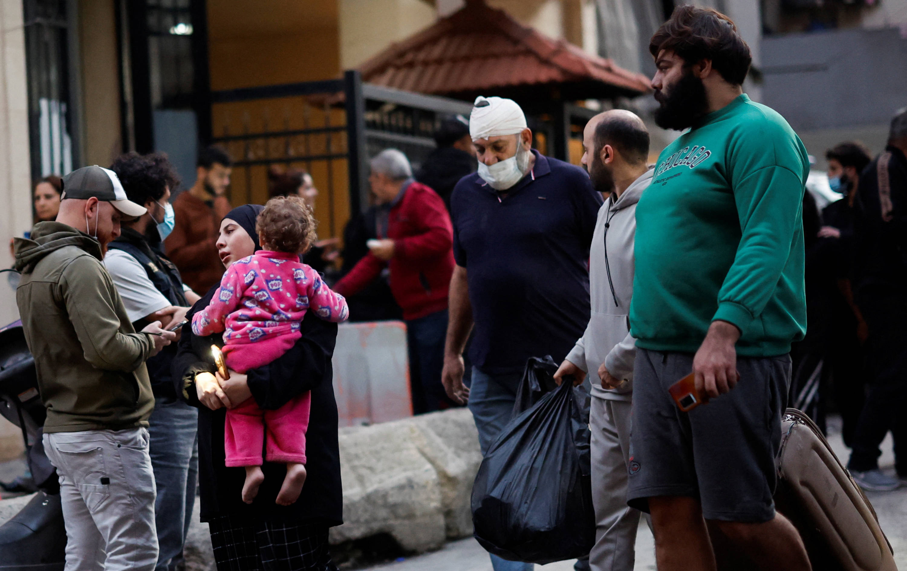 Residents evacuate with their belongings from the site of an Israeli strike in Beirut's Basta neighbourhood, Lebanon November 23, 2024 (Reuters)