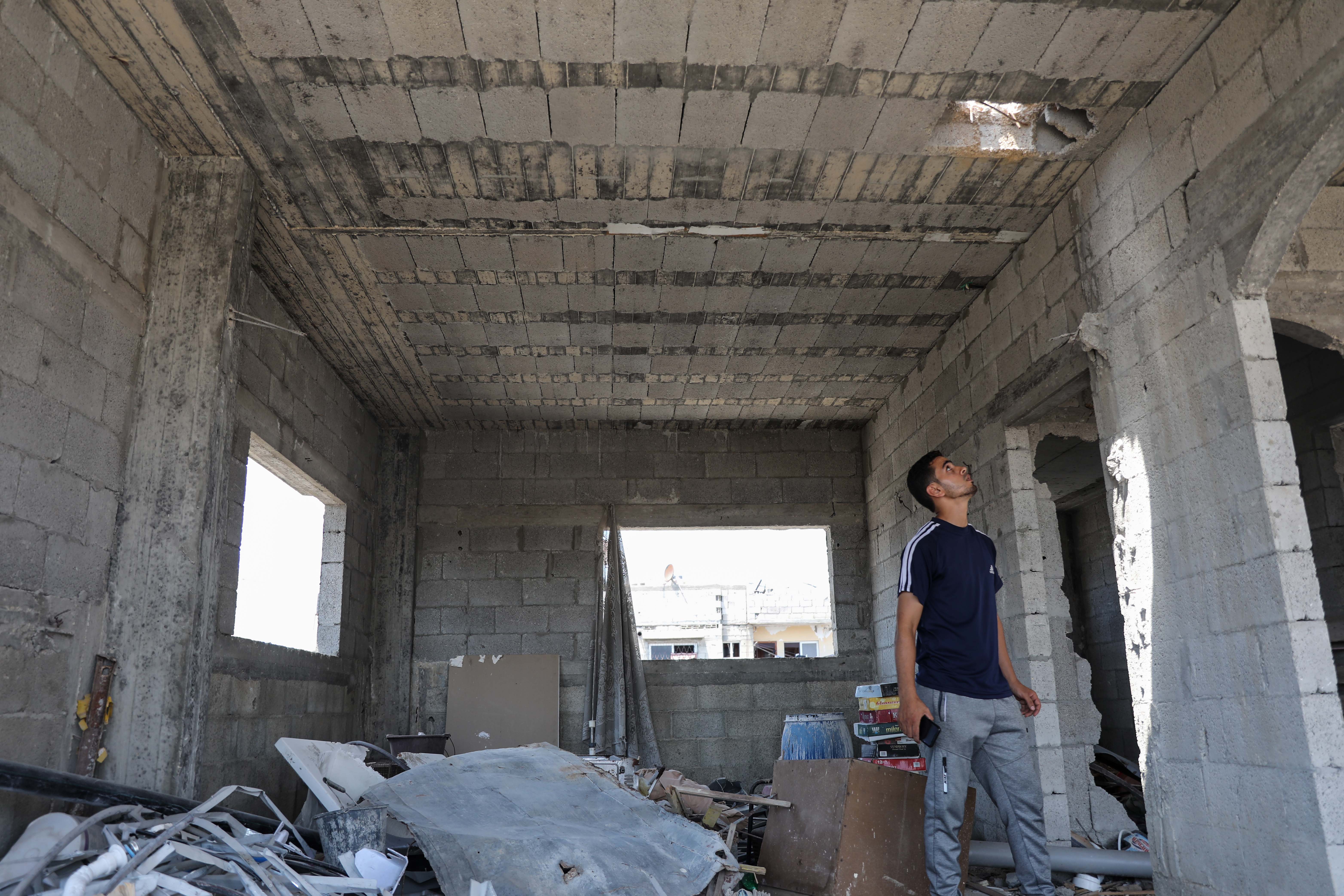 Au dernier étage de sa maison, Muhammed al-Rantissi observe le trou laissé par une bombe qui s’est écrasée sur son bâtiment et s’est profondément enfoncée dans la terre sans exploser. (MEE)