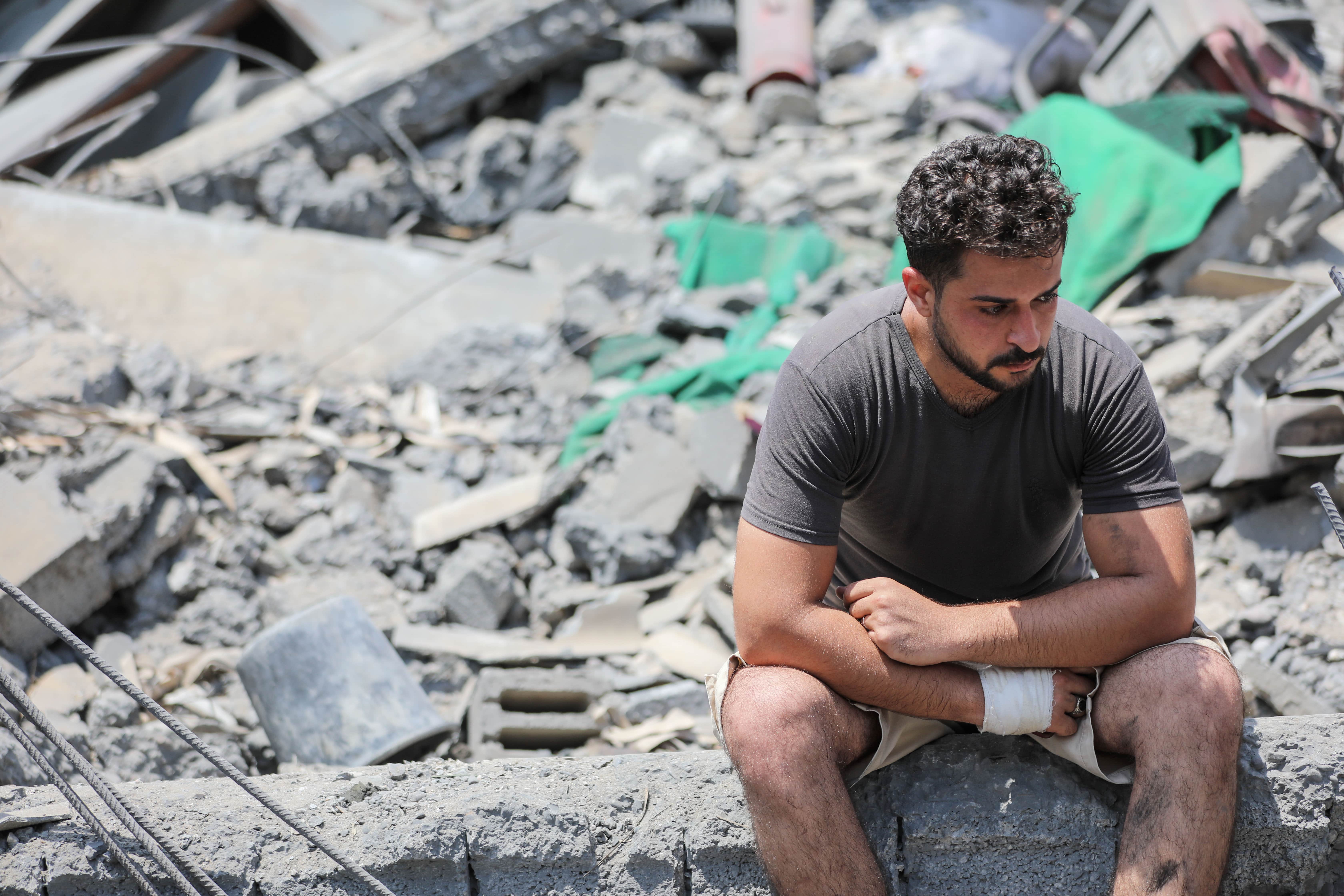 A Palestinian man sit at the rubble of a house flattened by Israeli air strikes in the Gaza Strip on 6 August 2022. (MEE/Mohammed al-Hajjar)