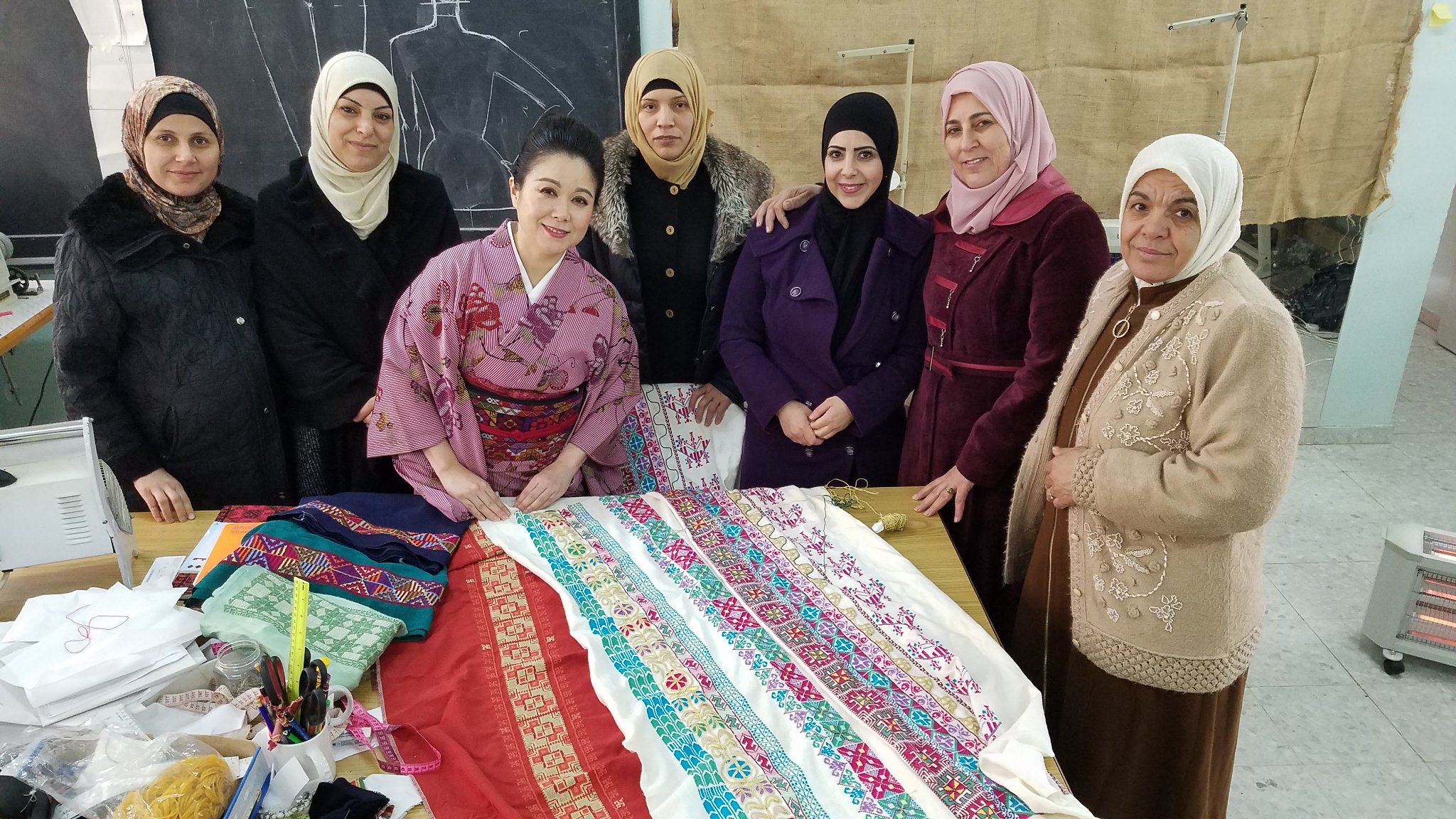 Yamamoto (third right) with Abu Shaweesh (second left) and other artisans in the Al-Amari refugee camp Ramallah (Credit: Palestinian Embroidery Obi Project)