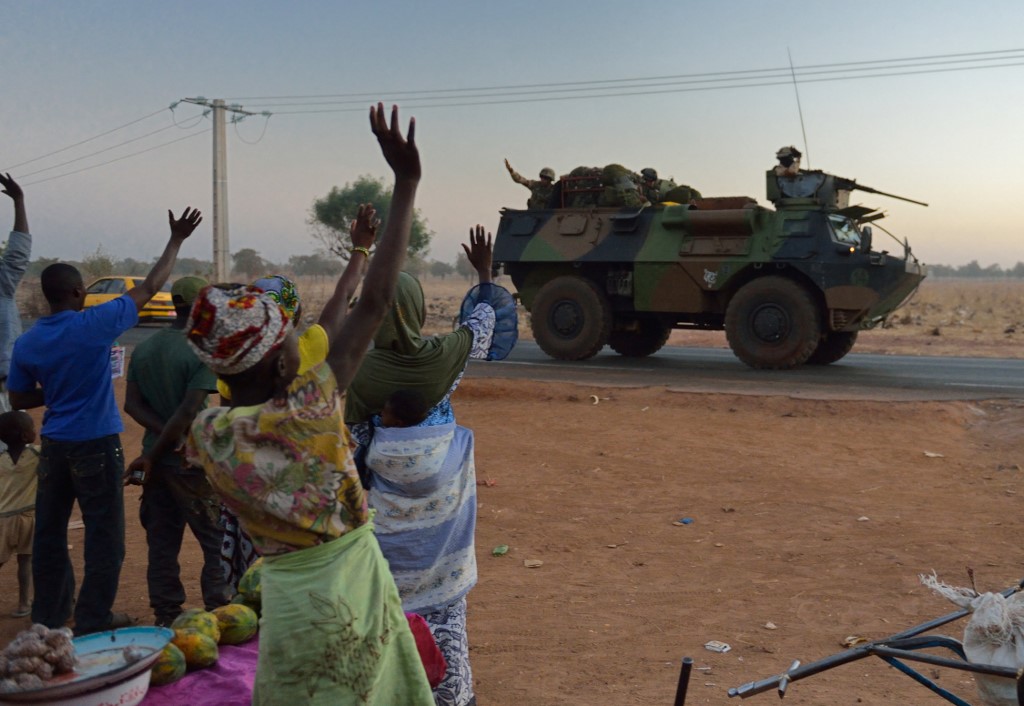 People wave to French soldiers in armoured vehicles in Mali's capital Bamako, deployed as part of Operation Serval, 15 January 2013 (AFP)