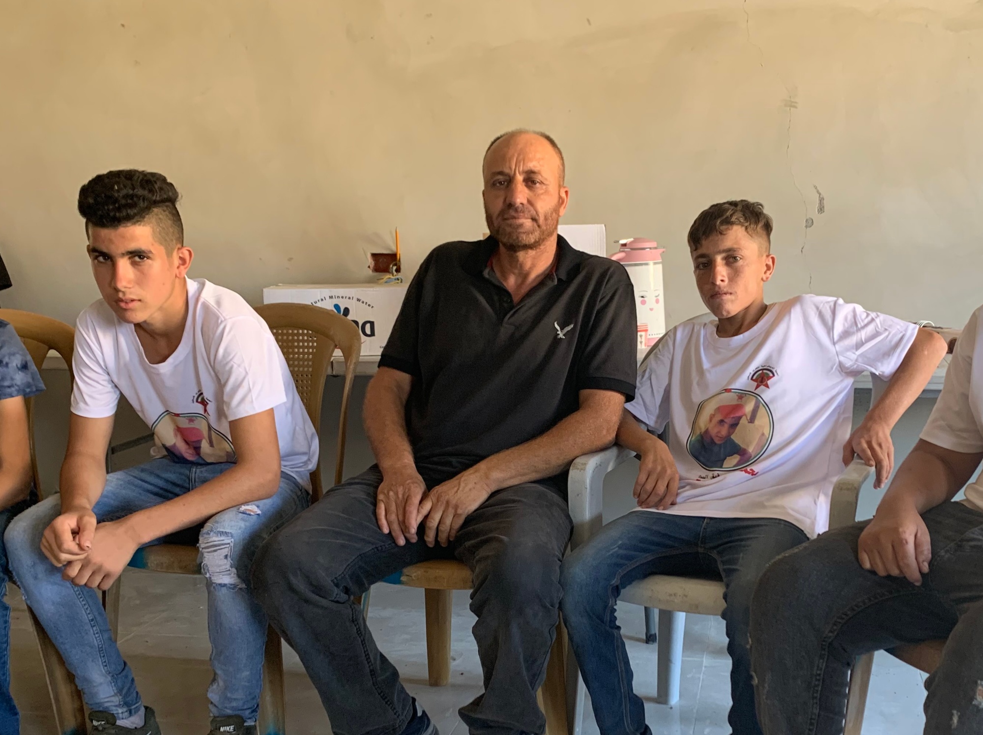 Daher Hreiz, Mohammad's father, is surrounded by his son's friends (MEE)
