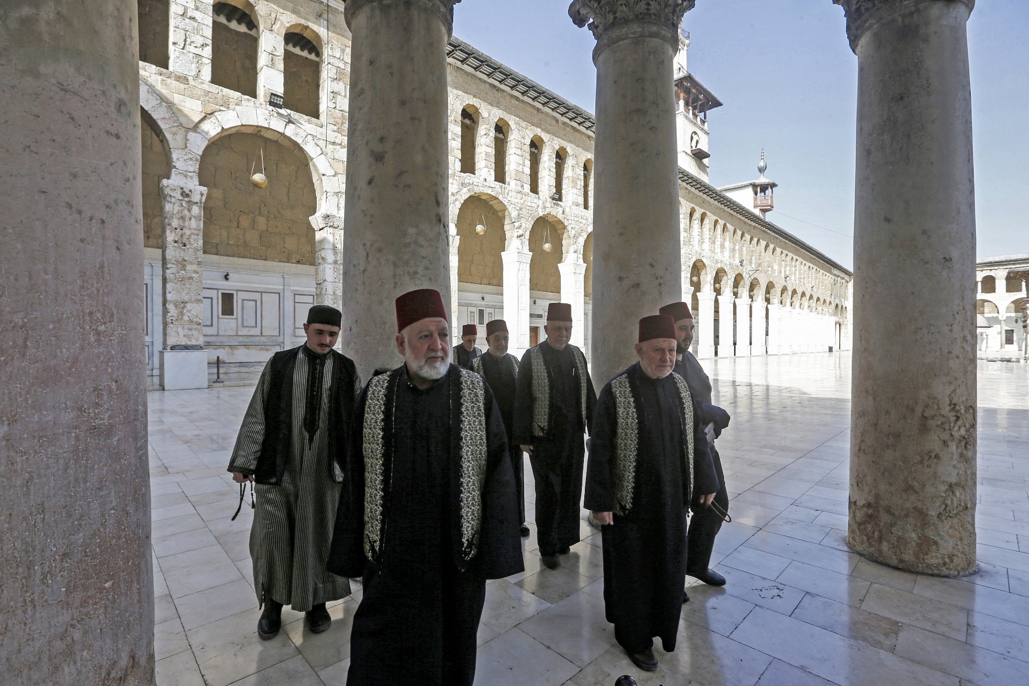 Muezzins, who call Muslims to prayer, arrive at the Umayyad Mosque in the ancient quarters of Damascus on March 11, 2020. Inside the Syrian capital's Great Umayyad Mosque, six muezzins sit before a loudspeaker, collectively reciting the call to prayer, their voices filling the air above the ancient quarters of Damascus. They are among 25 muezzins who take shifts