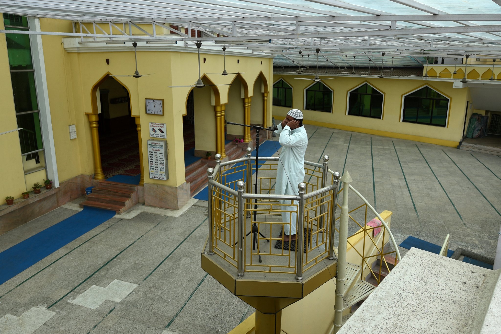 A Muezzin, person appointed to call Muslims to prayers, recites the azan (call to prayer) on the first day of the holy month of Ramadan during a government-imposed nationwide lockdown as a preventive measure against the COVID-19 coronavirus, at the Jame Masjid in Kathmandu on April 25, 2020. PRAKASH MATHEMA / AFP