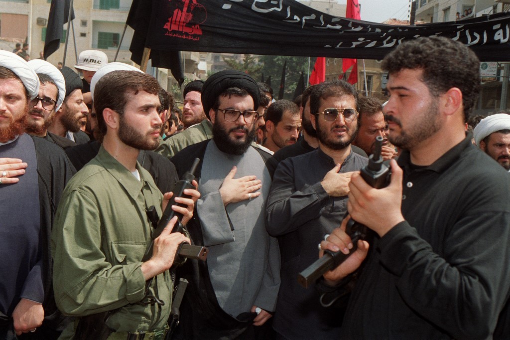 Hassan Nasrallah (C), the head of the Lebanese Hezbollah movement, surrounded by bodyguards, beats his chest while leading a gathering of thousands of Shia 10 July 1992 in Beirut (AFP)