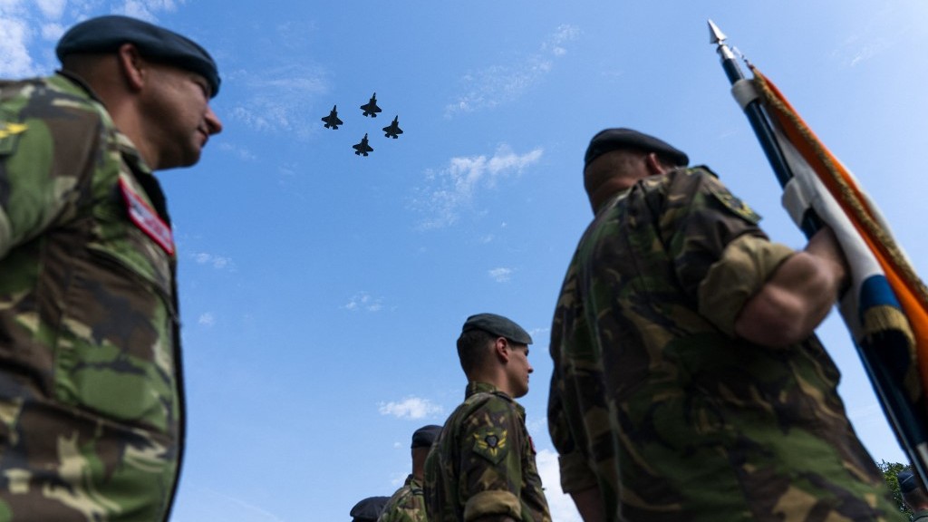 Dutch servicemen stand at attention as F-35 fighter jets fly over during a ceremony at Volkel Air Base in Uden on June 30, 2022. The F-35s will take over all tasks of the F-16 from 2024 (Jeroen JUMELET/ANP/AFP)