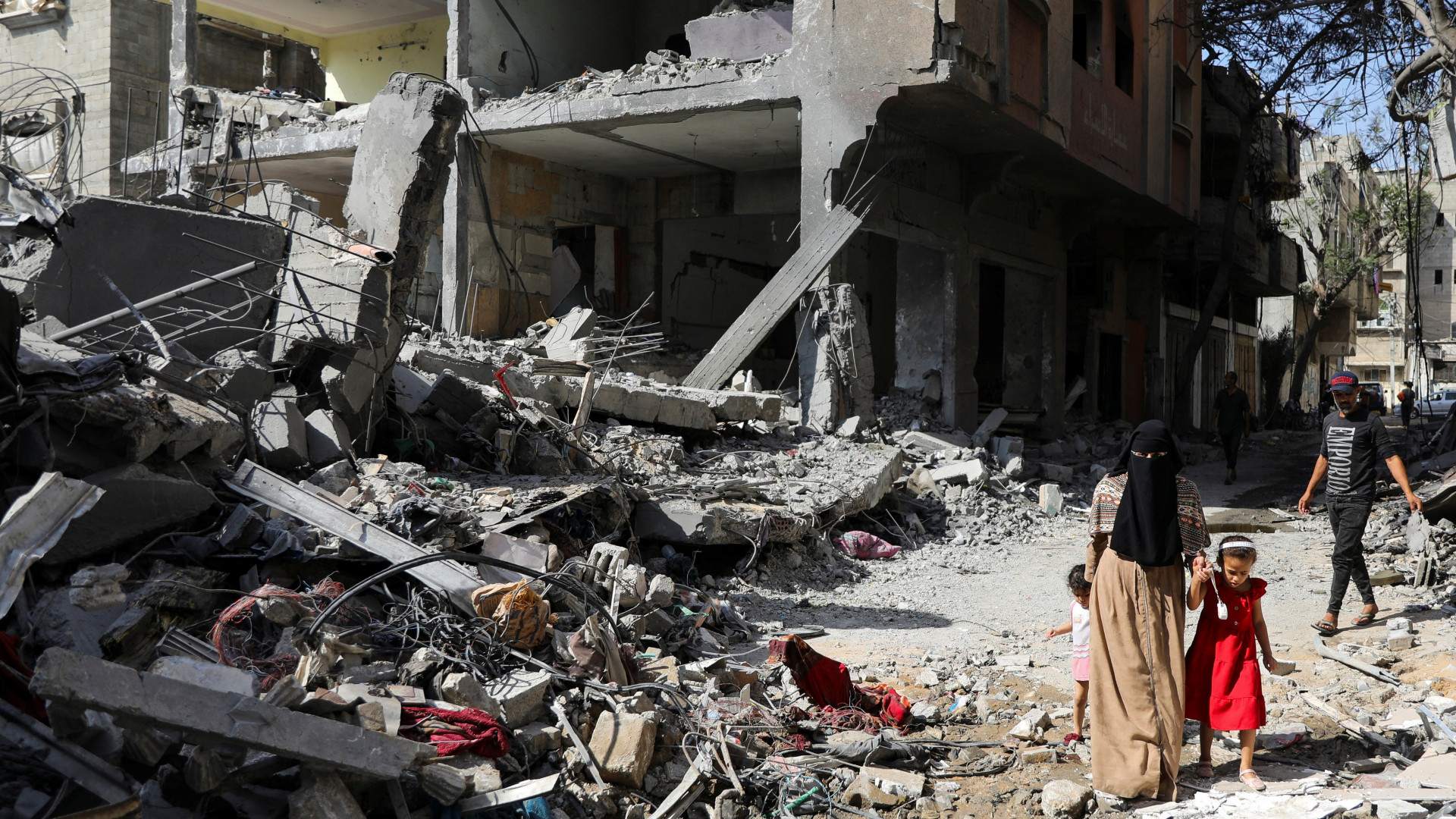 A woman and child walk among debris in the aftermath of Israeli strikes that killed 274 Palestinians in the Nuseirat refugee camp in central Gaza on 9 June 2024 (Reuters/Abed Khaled)