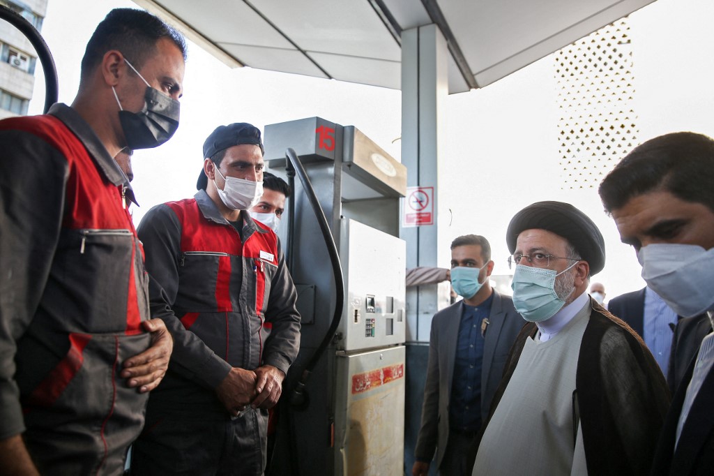 Iranian President Ebrahim Raisi (R) visiting a petrol station in Tehran on 27 October 2021