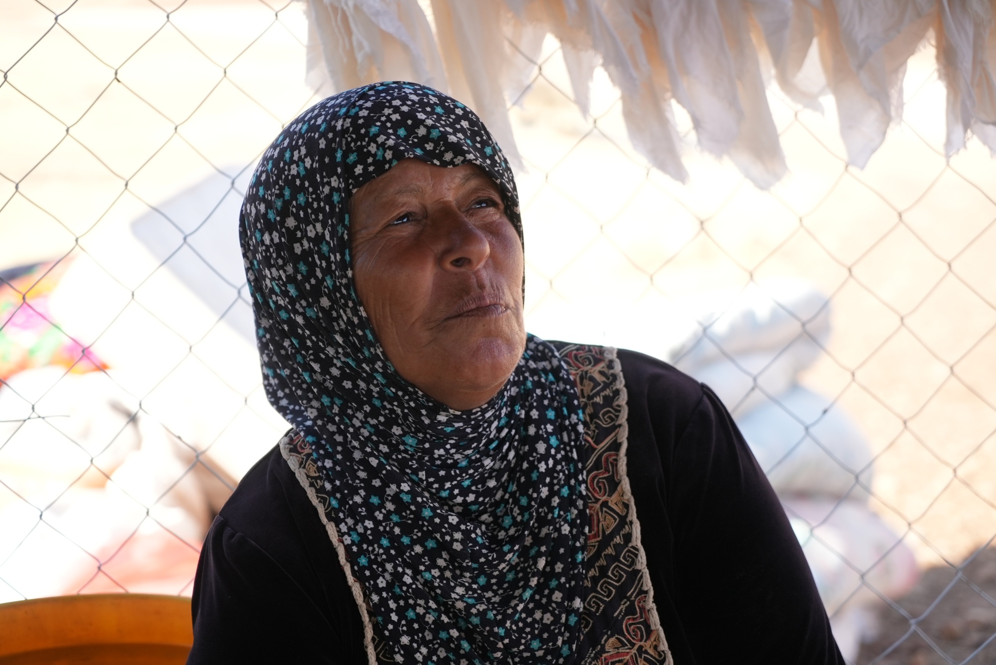 Aisha Abu Awwad sits underneath a makeshift tent in Khirbet Humsah. Since November 2020, her home has been demolished seven times (MEE/Akram al-Waara)