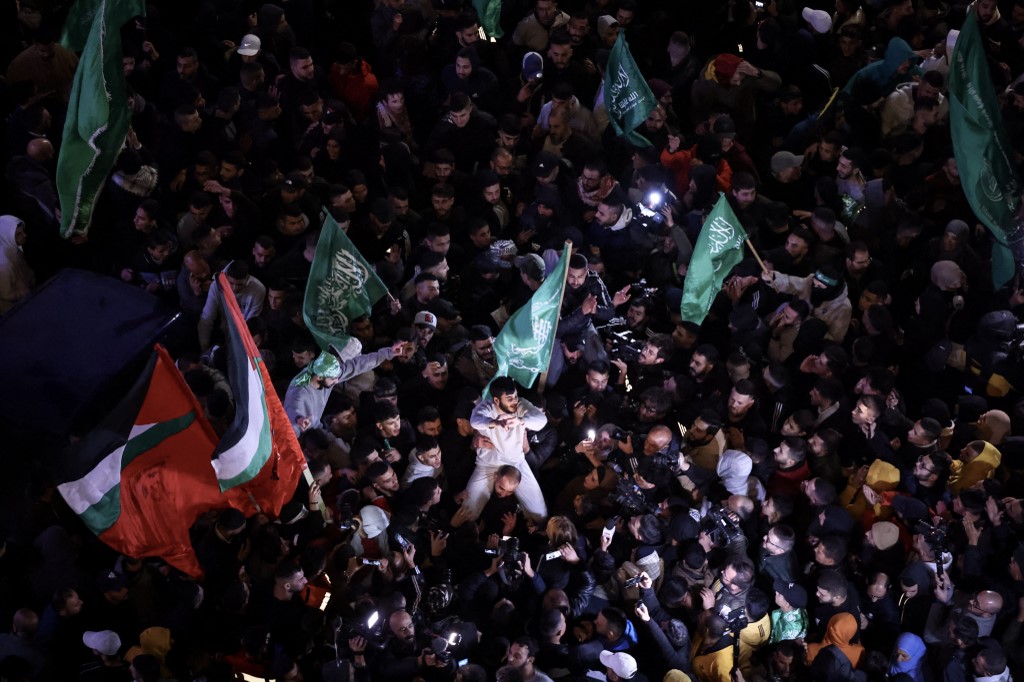 Palestinian prisoners are welcomed by a crowd after being released from Israeli jails, in Ramallah in the occupied West Bank on 26 November 2023 (AFP)