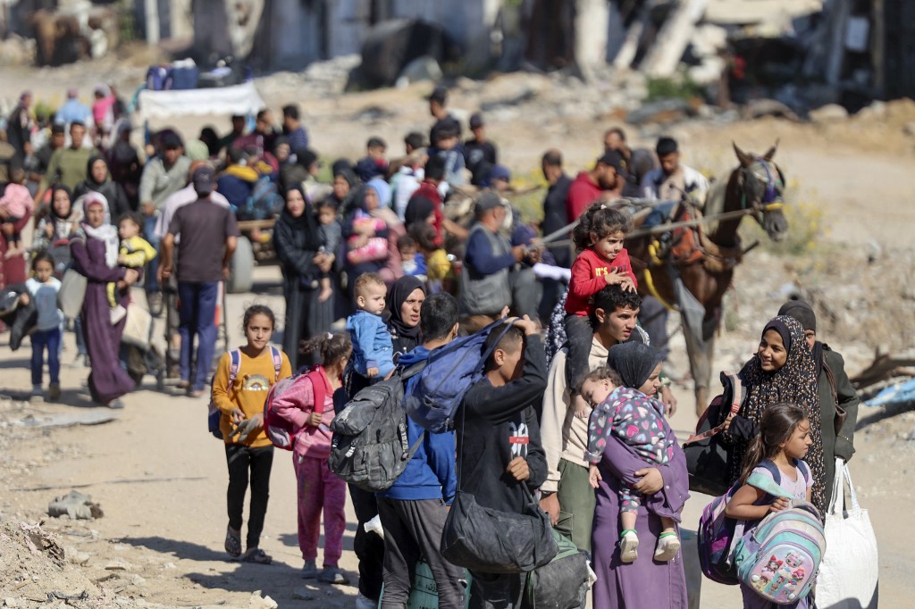 Displaced Palestinians fleeing Israeli military operations in Beit Lahia in the northern Gaza Strip, 22 October 2024 (Omar al-Qattaa/AFP)