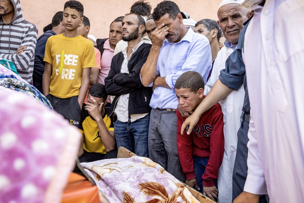 People mourn a victim killed in the Morocco earthquake in Moulay Brahim, al-Haouz province, on 9 September 2023 (AFP)