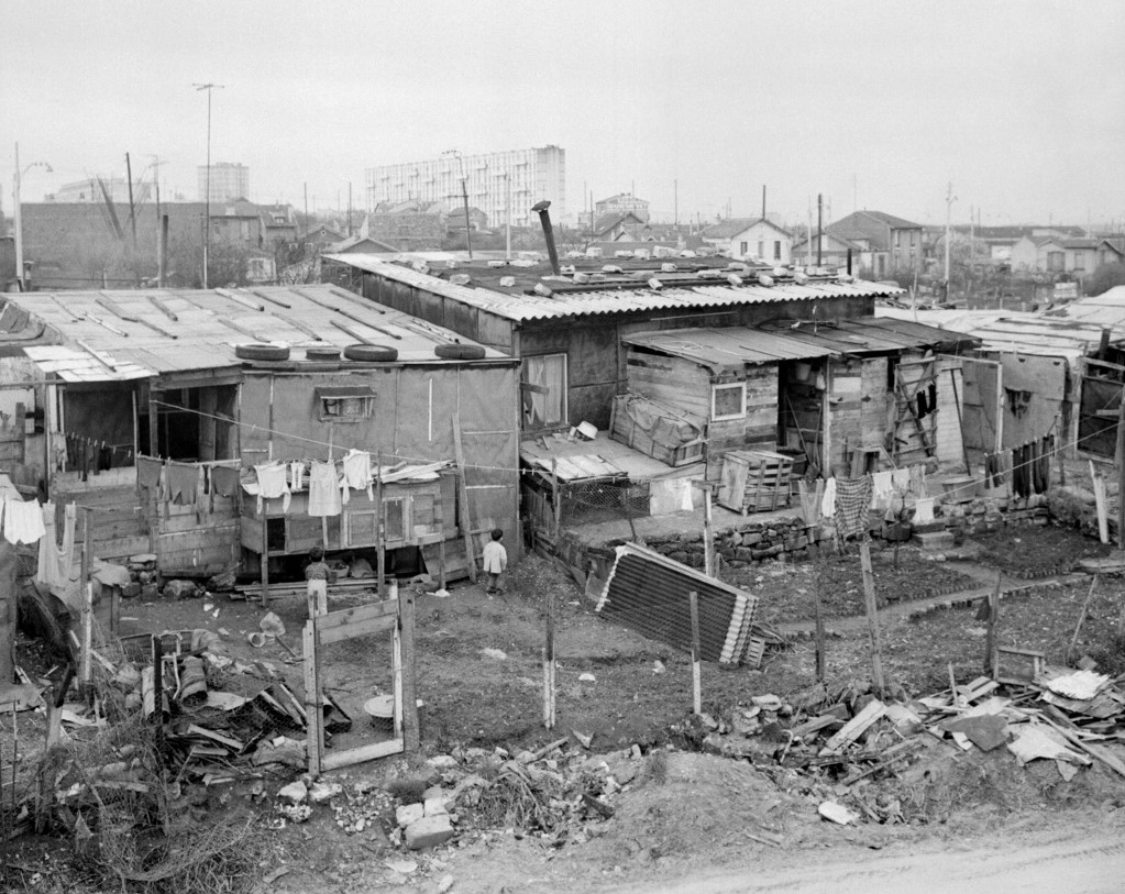 Photo prise le 24 mars 1964 du bidonville de Nanterre, où vit un grand nombre de familles d’immigrés algériens, avec en arrière-plan les grands ensembles d’immeubles HLM (AFP)