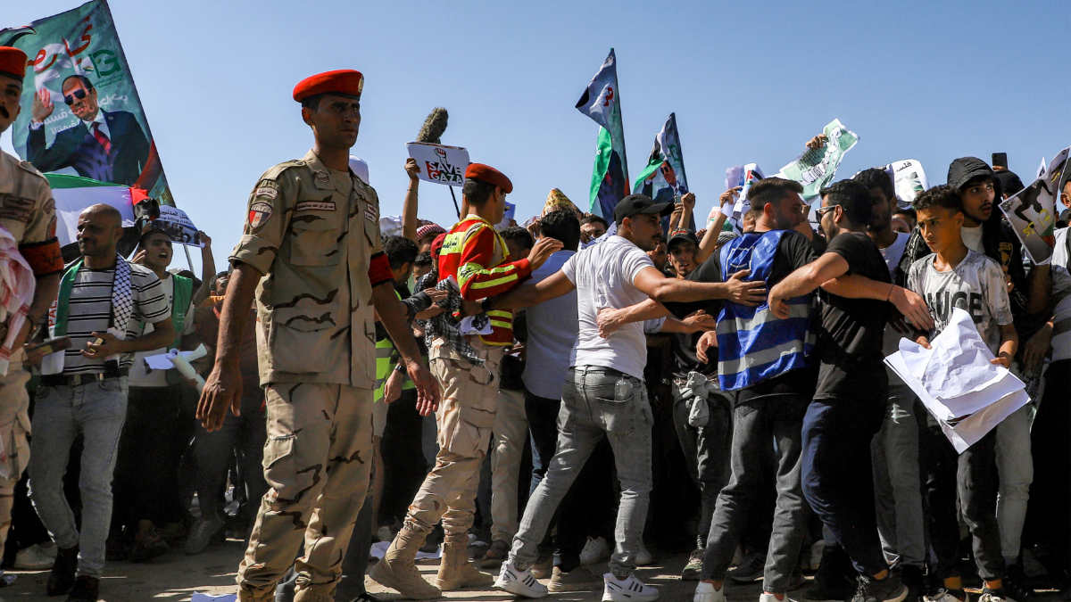 La police militaire égyptienne repousse des manifestants lors d’un rassemblement près du point de passage de Rafah avec la bande de Gaza du côté égyptien, dans l’est du gouvernorat du Sinaï Nord, le 20 octobre 2023 (AFP)