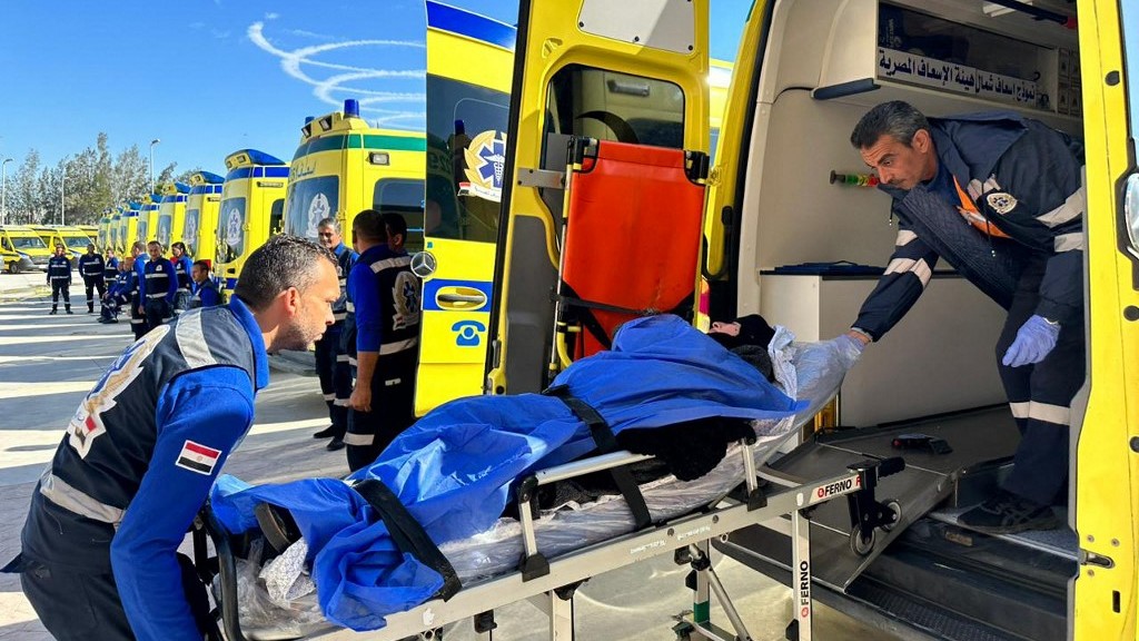 Egyptian paramedics transfer an injured Palestinian woman on the Egyptian side of the Rafah border crossing in November 2023 (AFP)