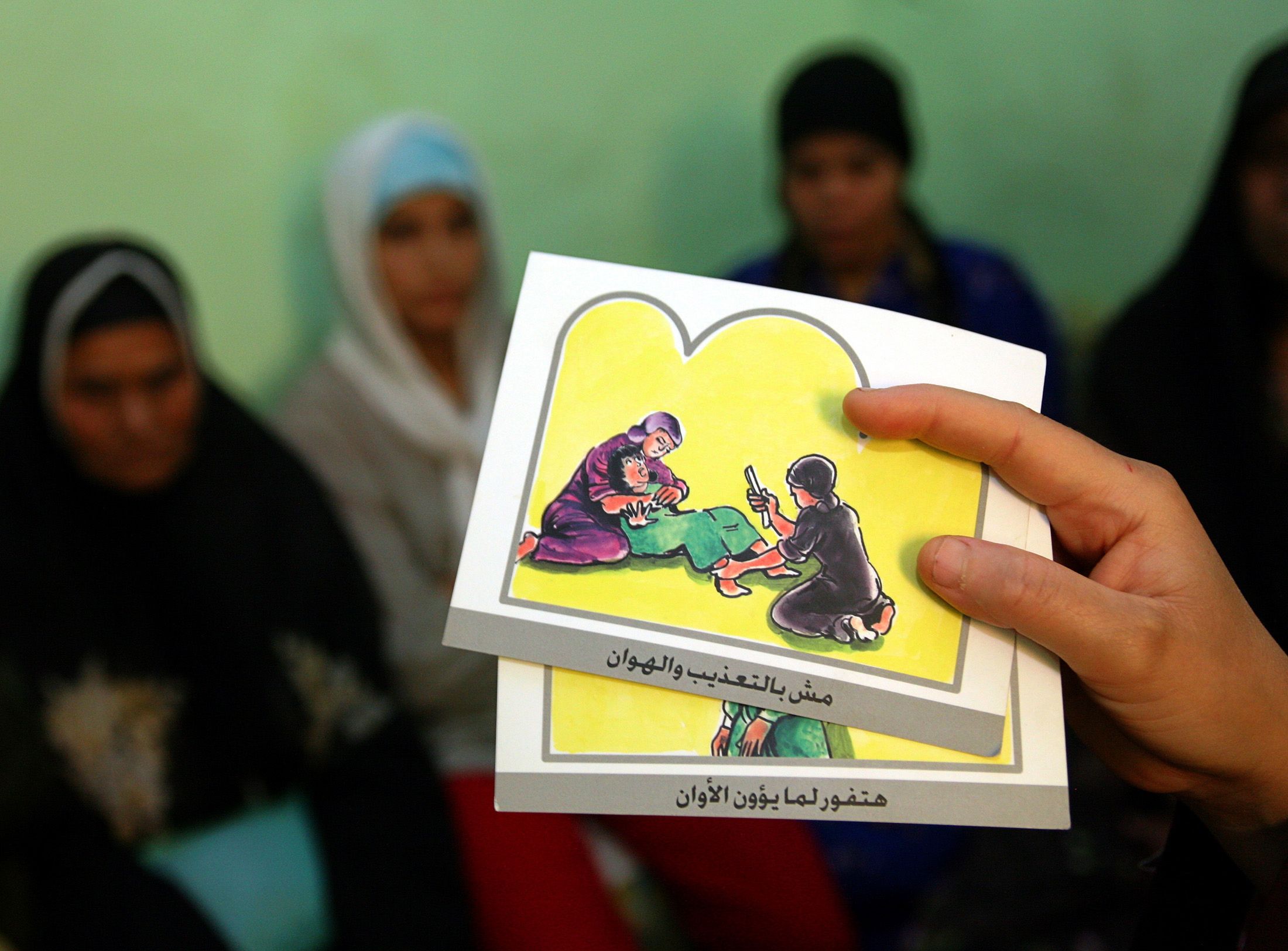 A counsellor holds up cards used to educate women about female genital mutilation (FGM) in Minia, Egypt, 2006 (Reuters)