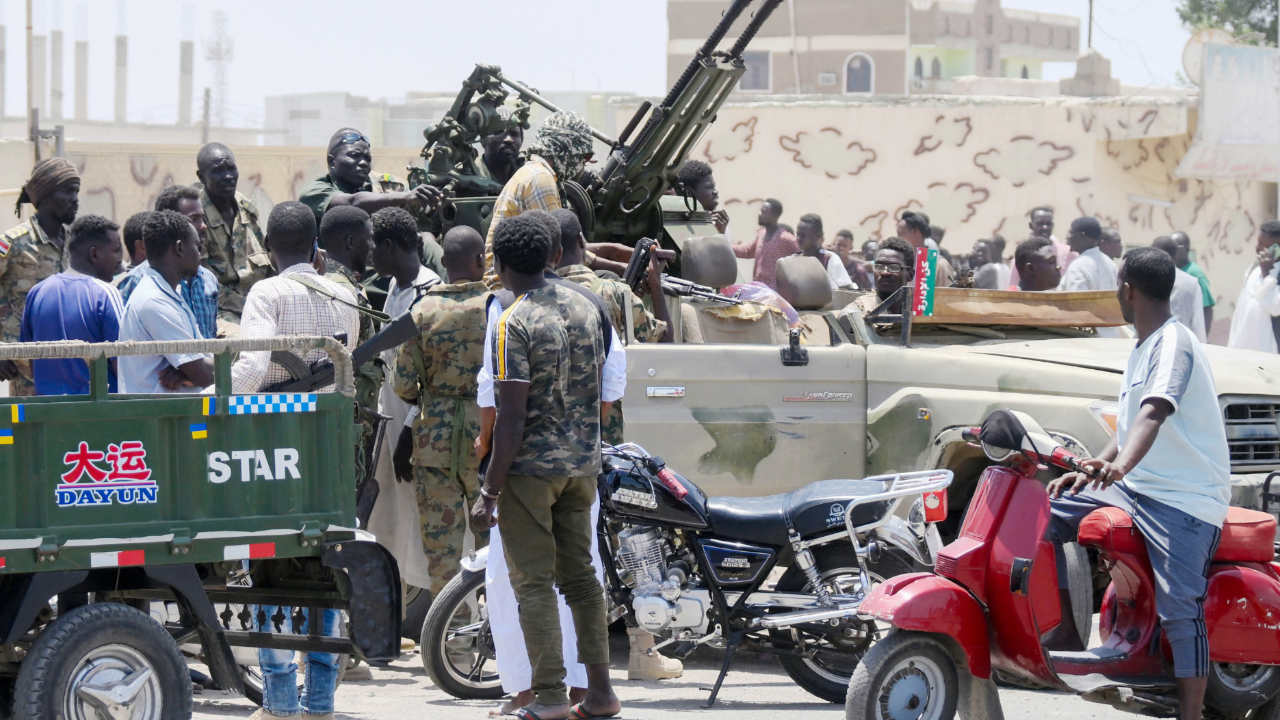 Des citoyens célèbrent des soldats de l’armée soudanaise fidèles au chef de l’armée Abdel Fattah al-Burhan, le 16 avril 2023 à Port-Soudan (AFP)