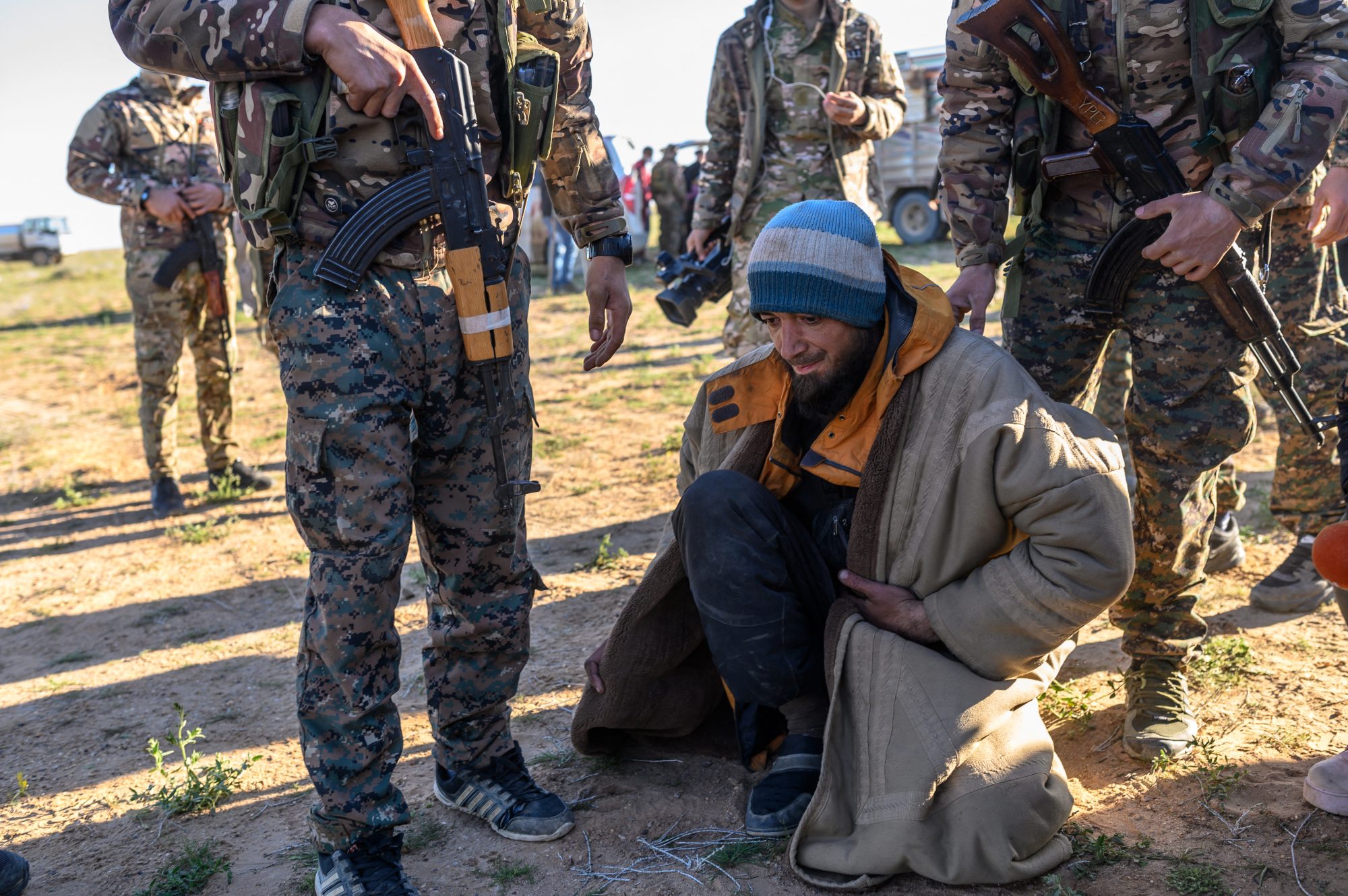 A man from Bosnia suspected of being an Islamic State fighter is searched by members of the Syrian Democratic Forces (SDF) after leaving the IS group's last holdout of Baghouz on 1 March 2019 (AFP)